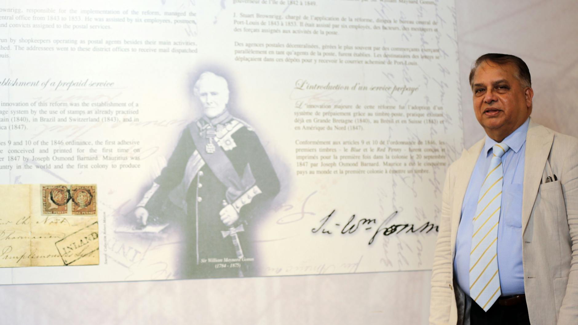 Giandev Moteea, der Direktor des Post-Museums, steht neben einem Porträt des Erfinders der Briefmarke, dem Briten Sir Rowland Hill.