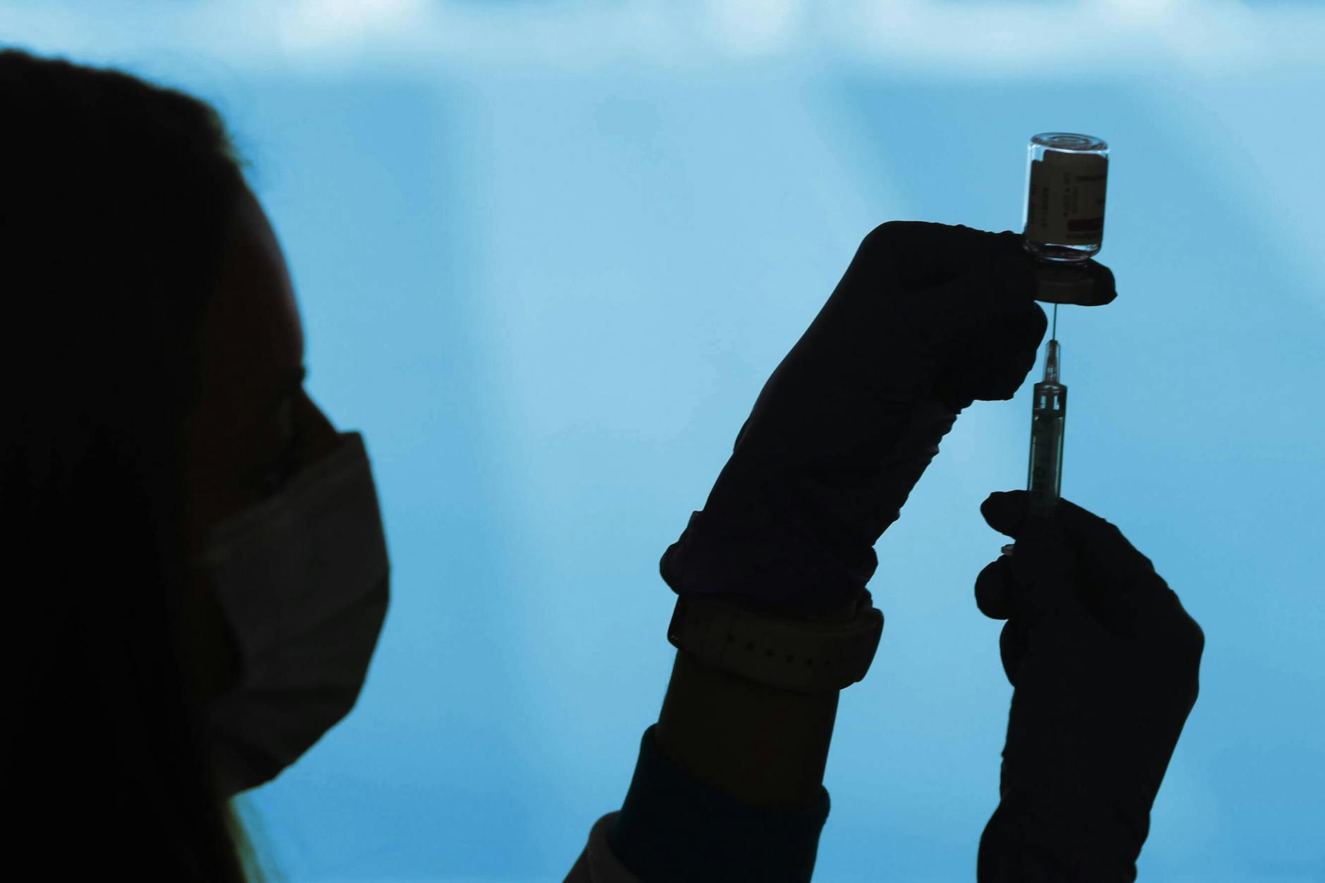 Ein Arzt bereitet eine Impfdosis vor.