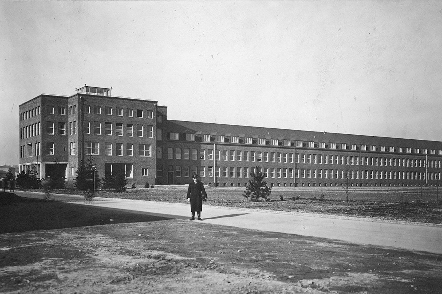 Das Verwaltungsgebäude der Henschel Flugzeug-Werke in Schönefeld, errichtet 1935 als architektonisches Symbol der modernen Zeit unter der Maxime: dauerhaft, sparsam, funktional. Im Vordergrund Werksdirektor Walter Hormel. Heute nutzt die BER-Verwaltung das Gebäude, im Kopfbau links residiert die Geschäftsführung.