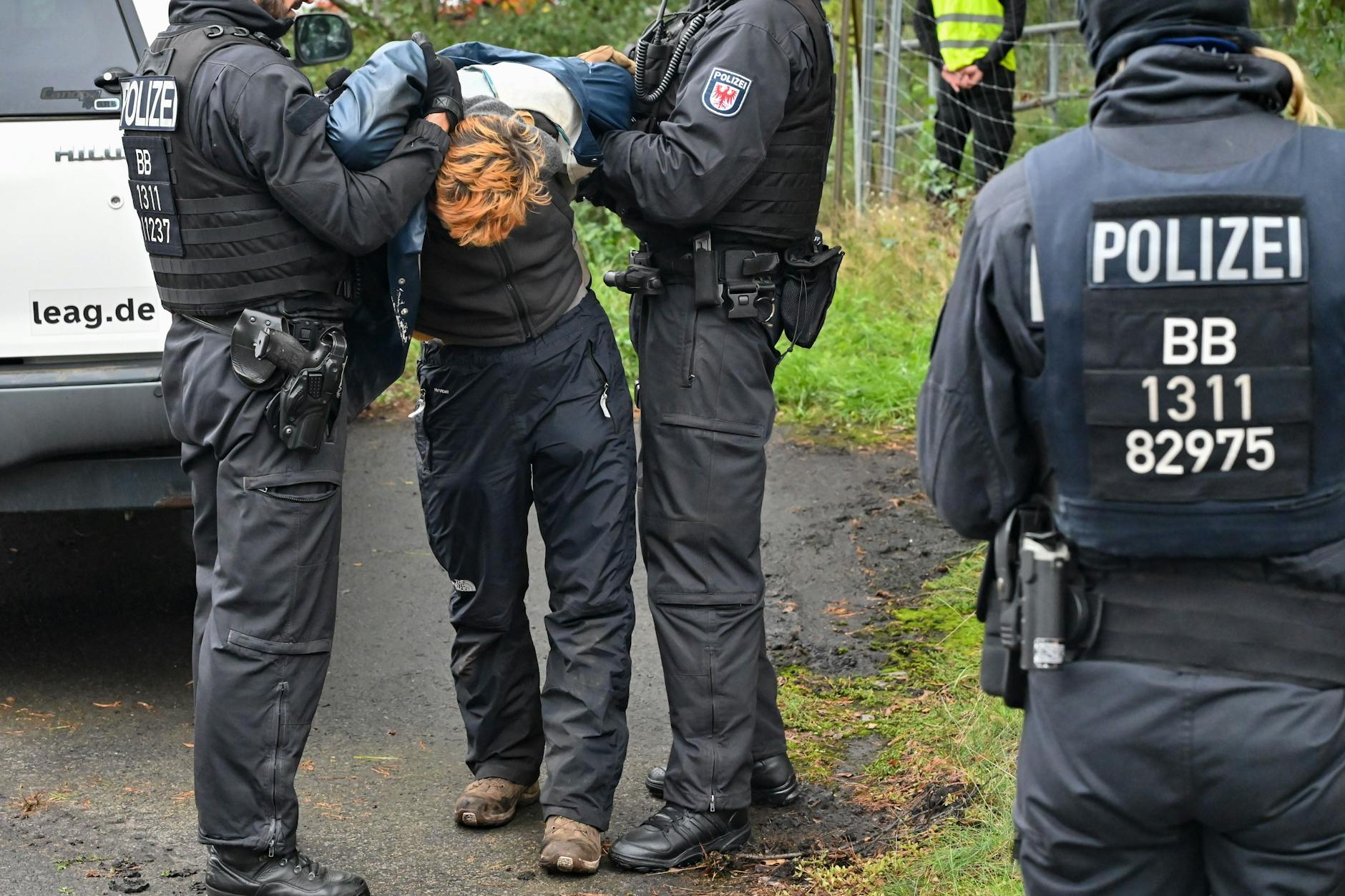 Ein Klimaaktivist wird von der Polizei abgeführt, nachdem er eine Gleisverbindung für den Transport von Braunkohle zum Kraftwerk Jänschwalde blockiert hatte.