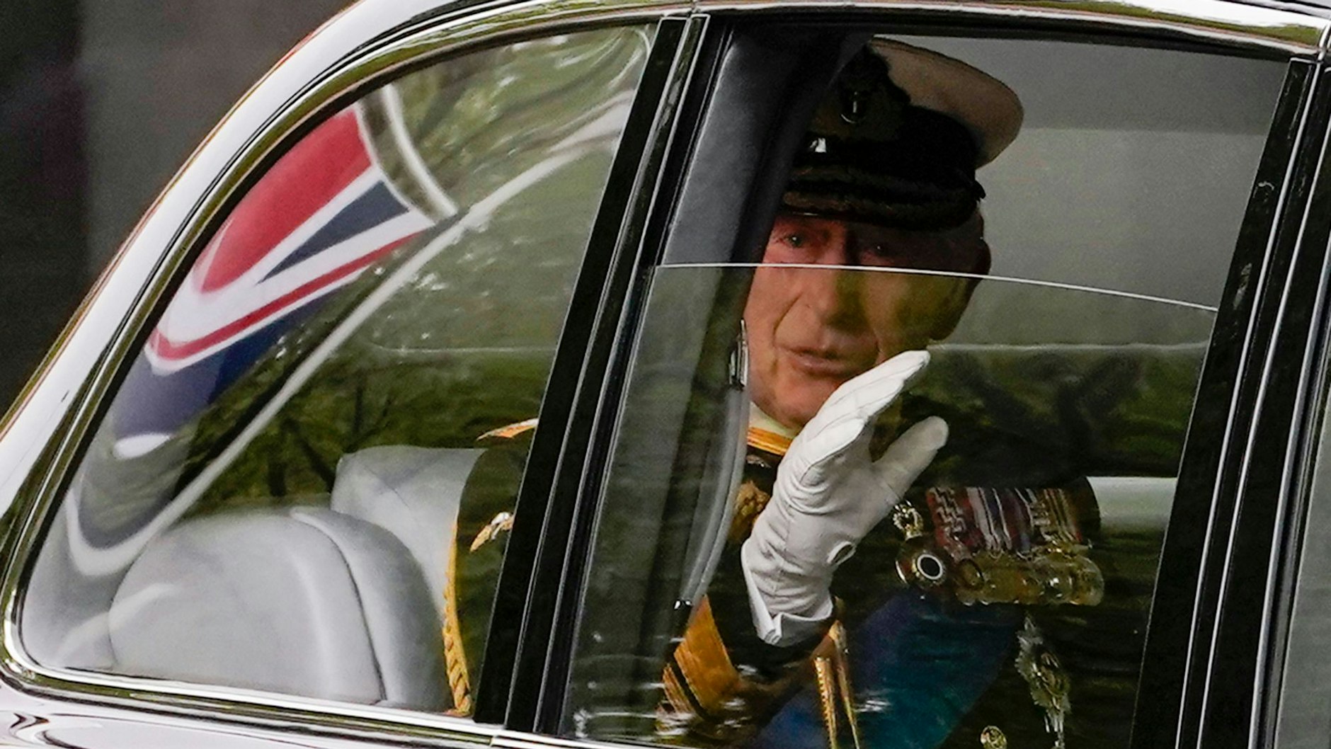 König Charles III. winkt, als er am Montag, den 19. September 2022, zur Beerdigung seiner Mutter, Königin Elizabeth II., in die Westminster Abbey im Zentrum von London gefahren wird.