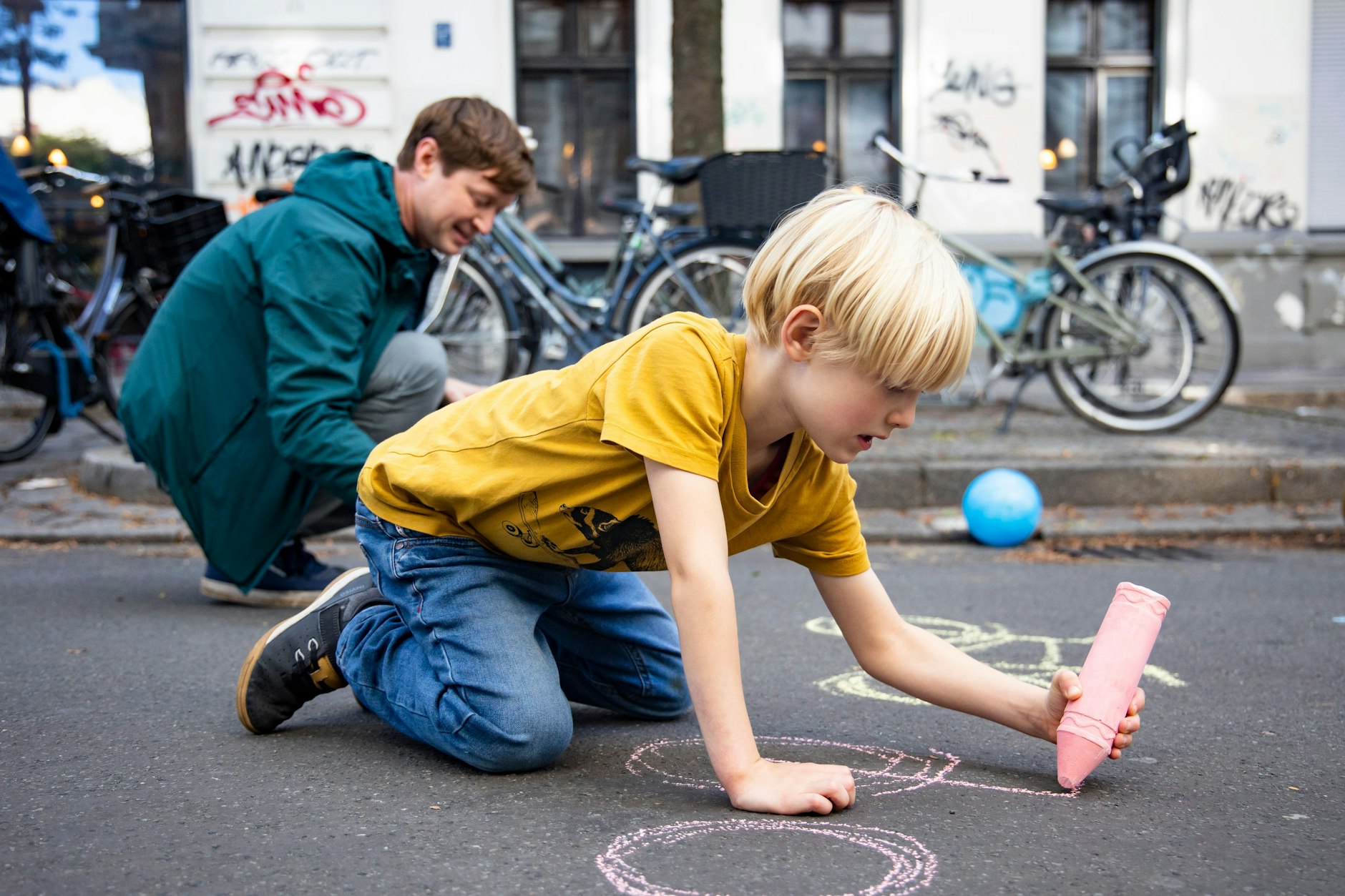 Temporäre Fahrräder auf der Straße: Der kleine Emil (6) und sein Papa Bodo P. (42) zeichnen mit Kreide auf dem Asphalt.&nbsp;