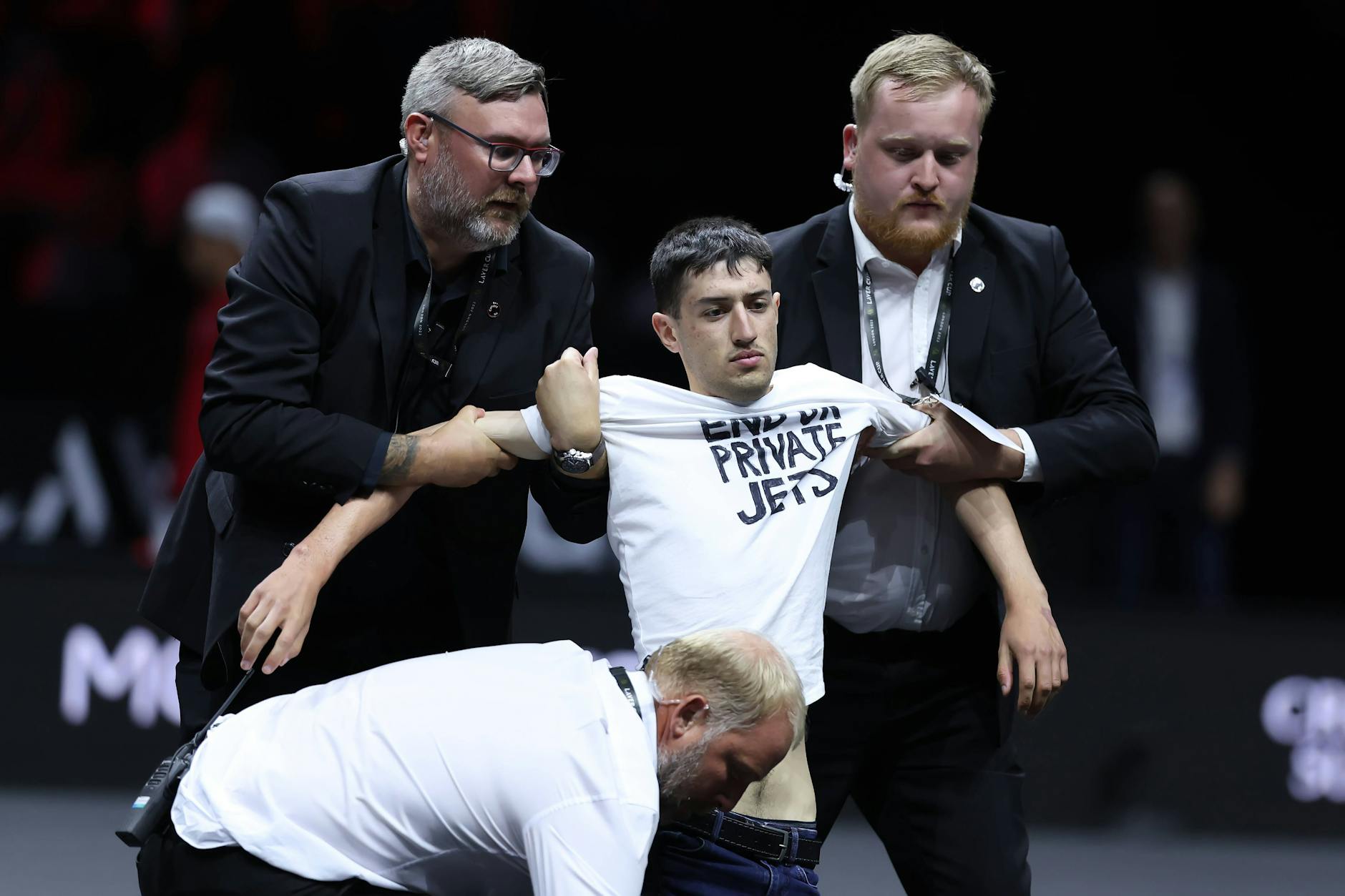 Sicherheitskräfte tragen den Klimaaktivist vom Feld.