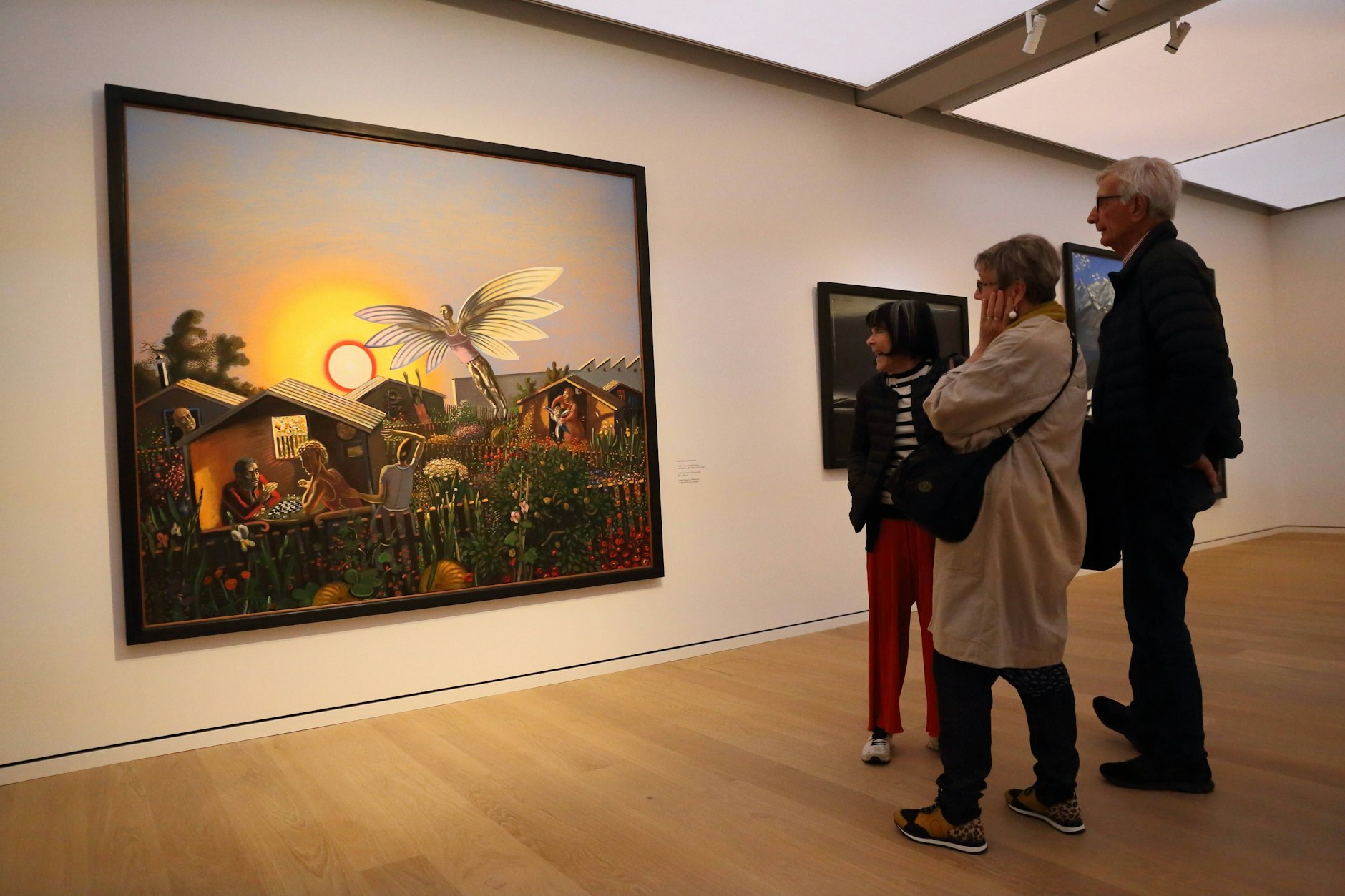 Drei Menschen betrachten das Gemälde „Der Nachbar, der will fliegen “von Wolfgang Mattheuer in der Ausstellung im Das Minsk Kunsthaus in Potsdam. 