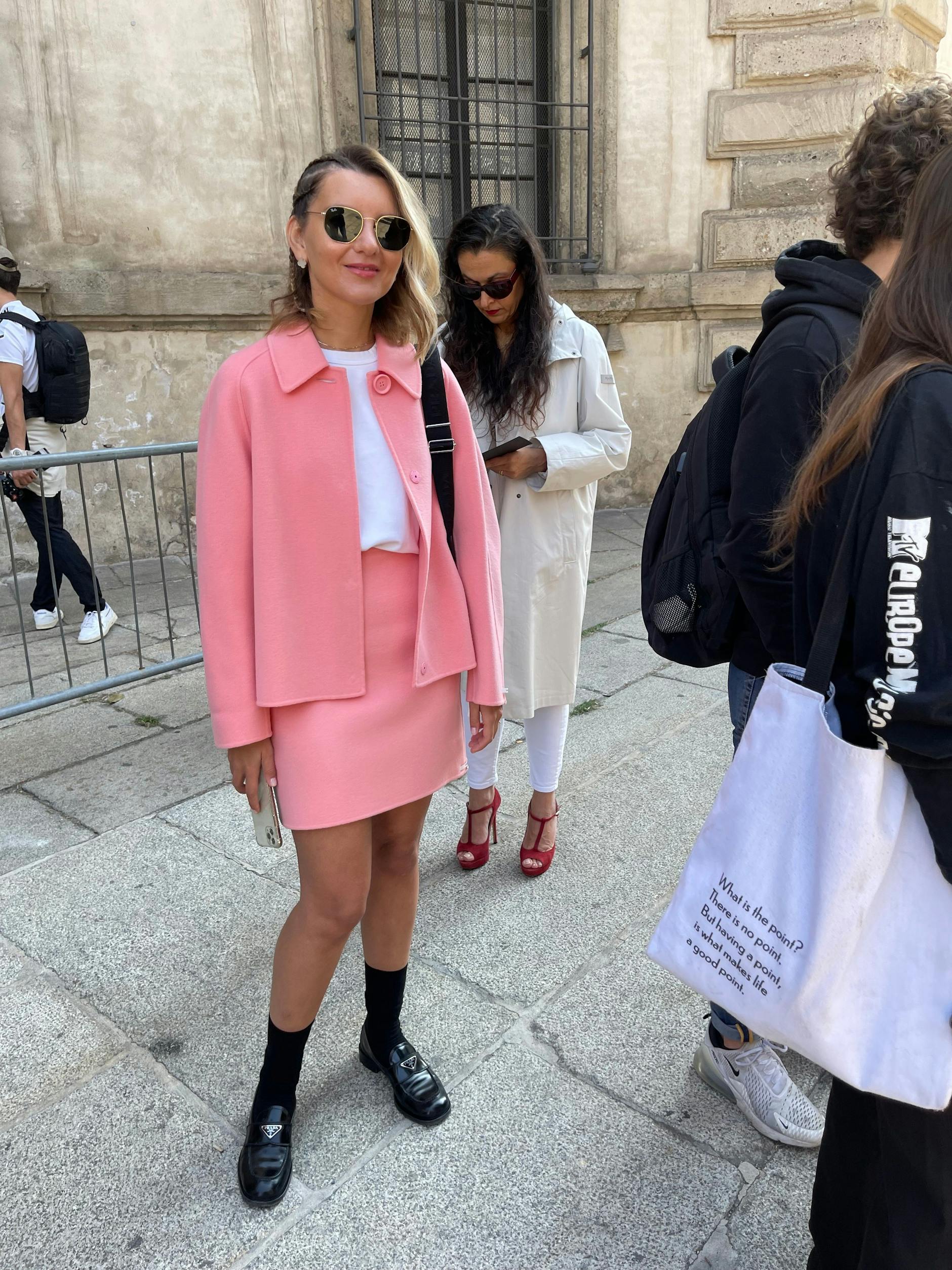 Gekonnter Bruch: zum femininen Kostüm ein weißes T-Shirt, schwarze Socken und Prada-Loafer.