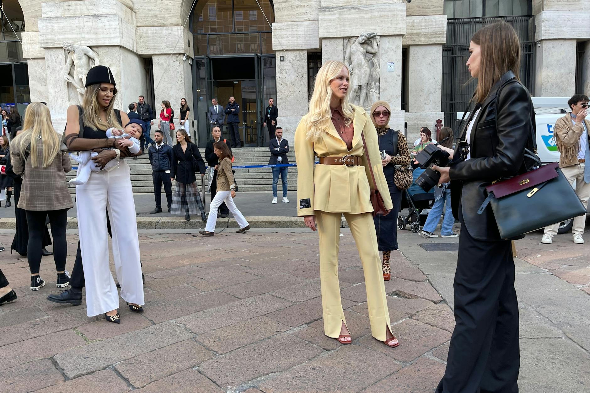 Man weiß gar nicht, wohin man zuerst schauen soll. Links zur Mutter mit Kind oder rechts zur Blondine im hellgelben Zweiteiler.