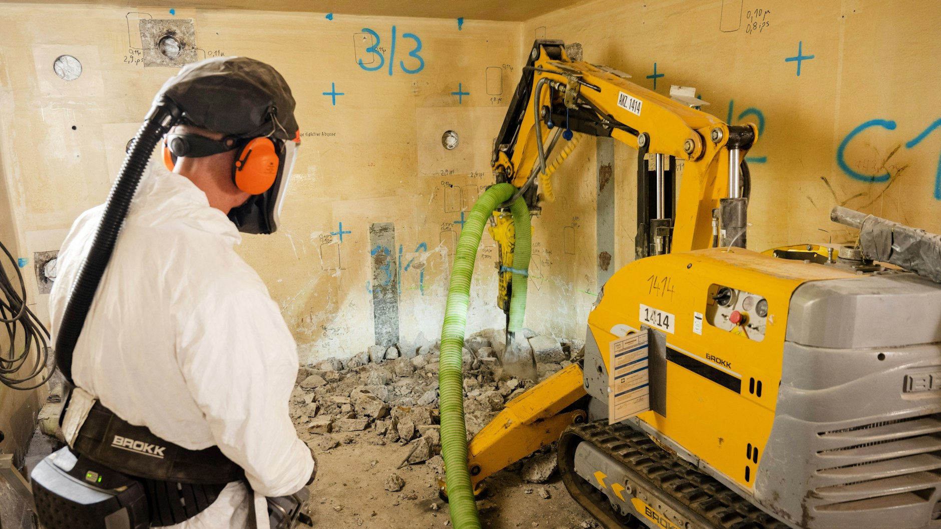 Ein Mitarbeiter arbeitet mit einem Abrissroboter im Spezialgebäude II im Kernkraftwerk Lubmin, um einen Betonblock zu zertrümmern.