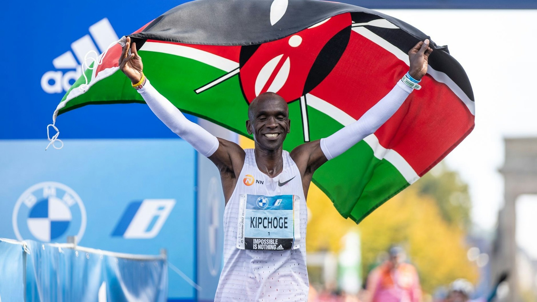 Eliud Kipchoge jubelt mit der kenianischen Flagge. Er lief den Marathon in Weltrekordzeit.