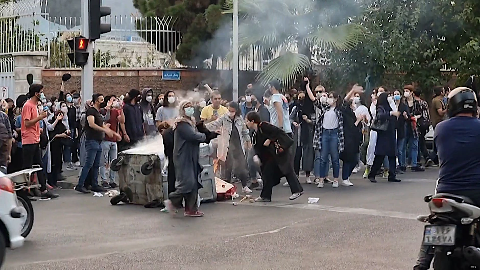 Ein Screenshot aus einem Zeugenvideo zeigt, wie iranische Demonstrantinnen in Teheran ihre Kopftücher verbrennen und eine Mülltonne in Brand setzen.