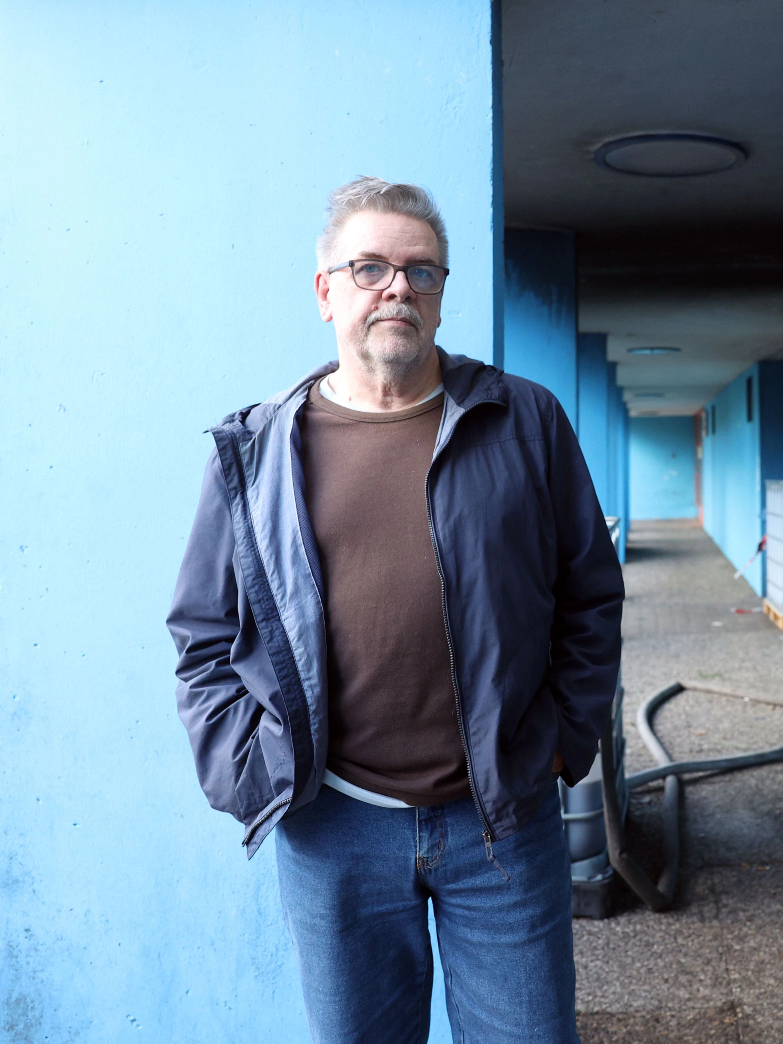 Mieter Uwe Marsiske (68) wartet darauf, dass der Aufzug repariert wird. Die Schläuche hinter ihm sind für Wasserzufuhr und Abfluss.