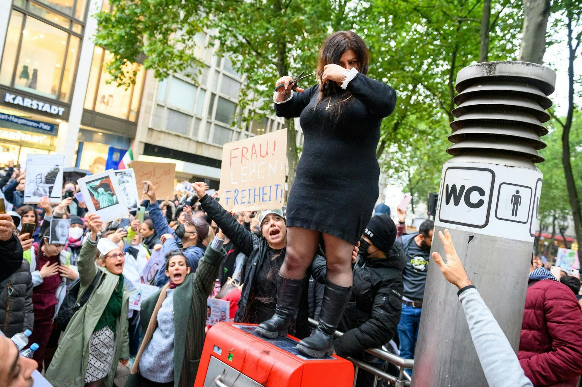 Eine Frau schneidet sich in Hamburg demonstrativ die Haare ab, um sich mit den Frauen im Iran zu solidarisieren.