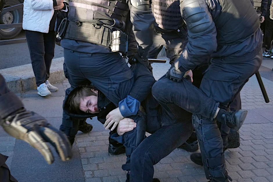 Russische Polizisten gehen gegen einen Demonstranten während eines Protestes gegen die russische Teilmobilisierung in St. Petersburg vor.  