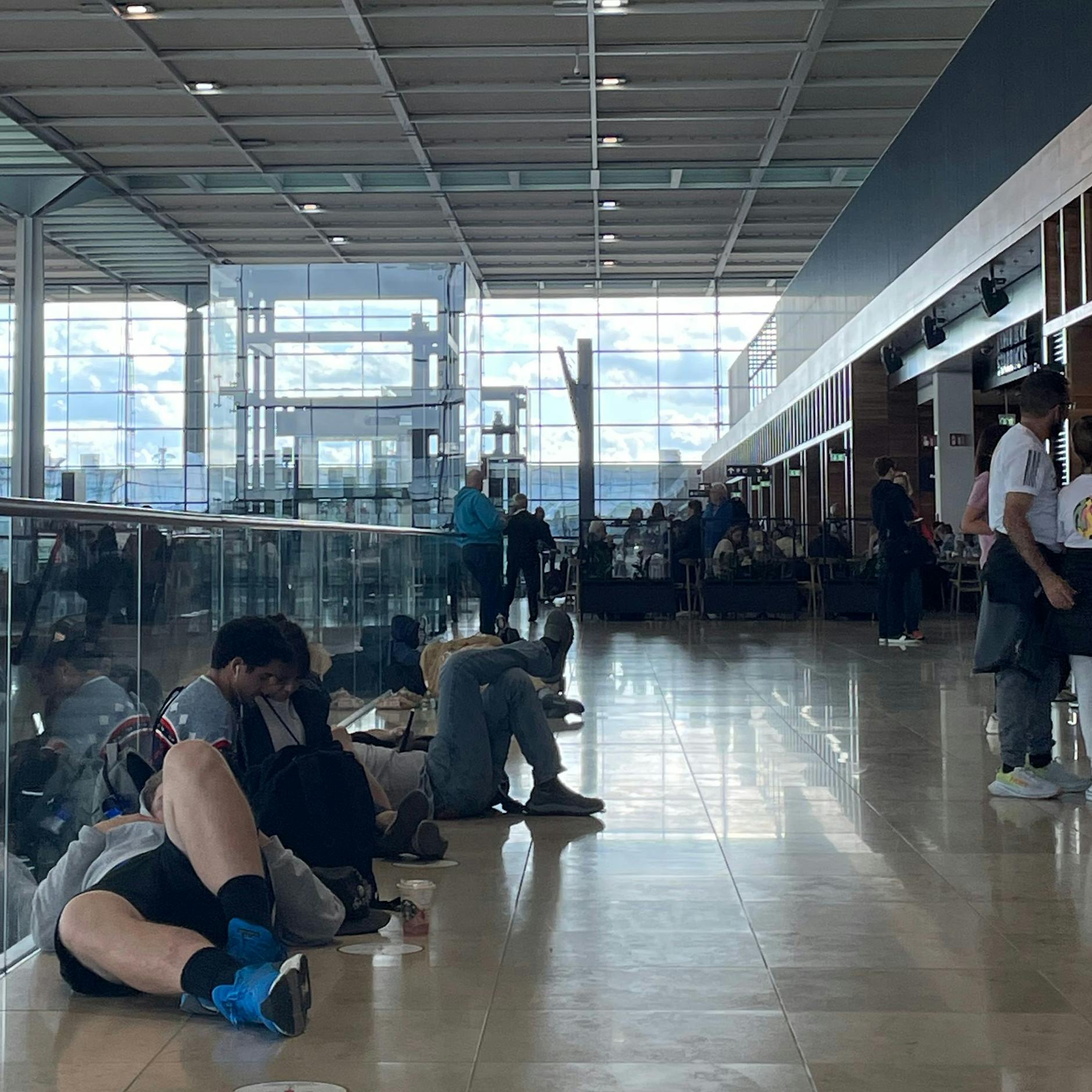 Menschen dösen vor dem Lufthansa-Schalter.