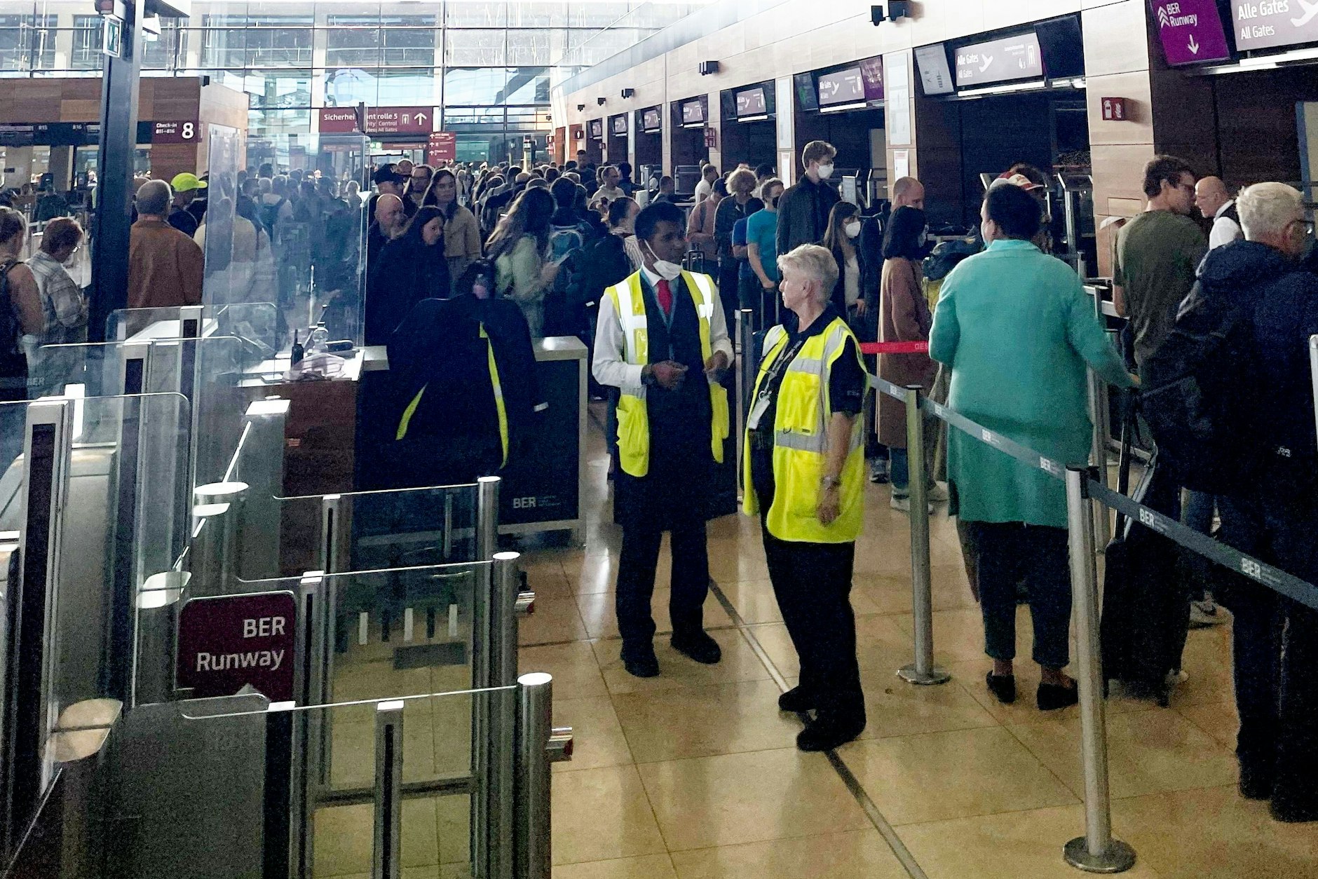 Zahlreiche Menschen stehen für die Sicherheitskontrolle an. Geschätzte Wartezeit: über 45 Minuten.