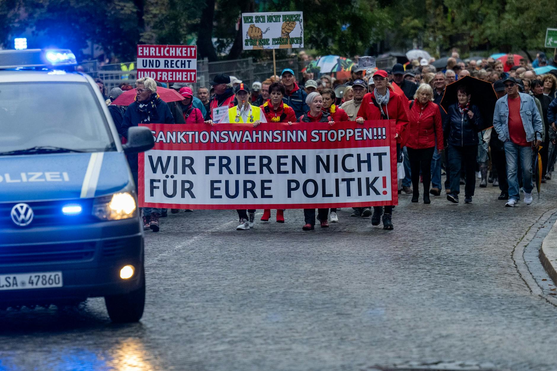 Demonstranten ziehen bei Regen durch Halle in Sachsen-Anhalt. 