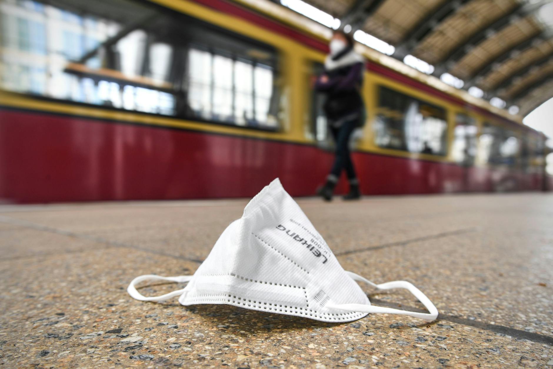 Eine Maske liegt auf dem Boden eines S-Bahnhofs.