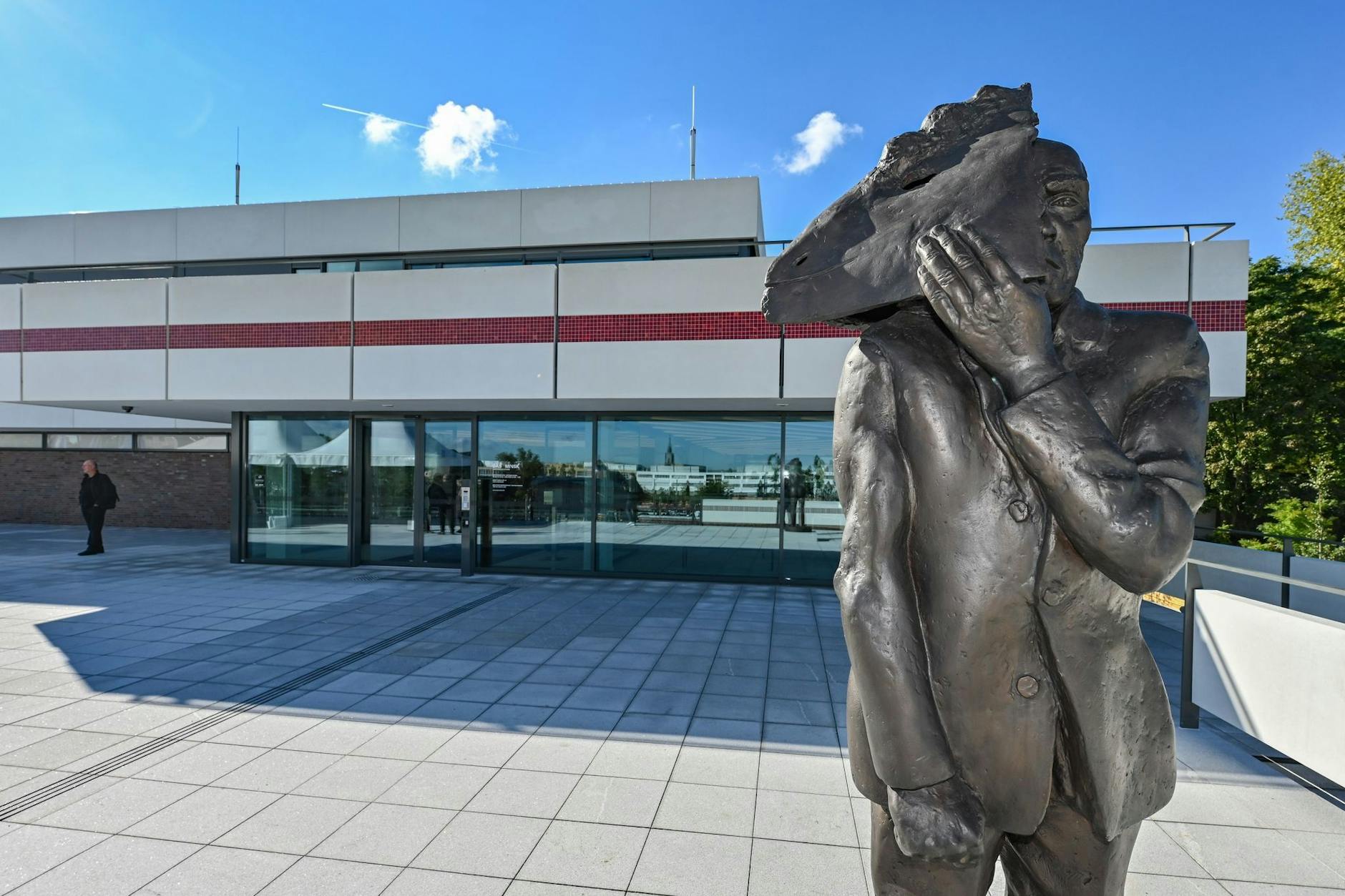 Mattheuers Bronzeskulptur „Maskenmann / Gesicht zeigen“ steht vor dem Kunsthaus Minsk in Potsdam.