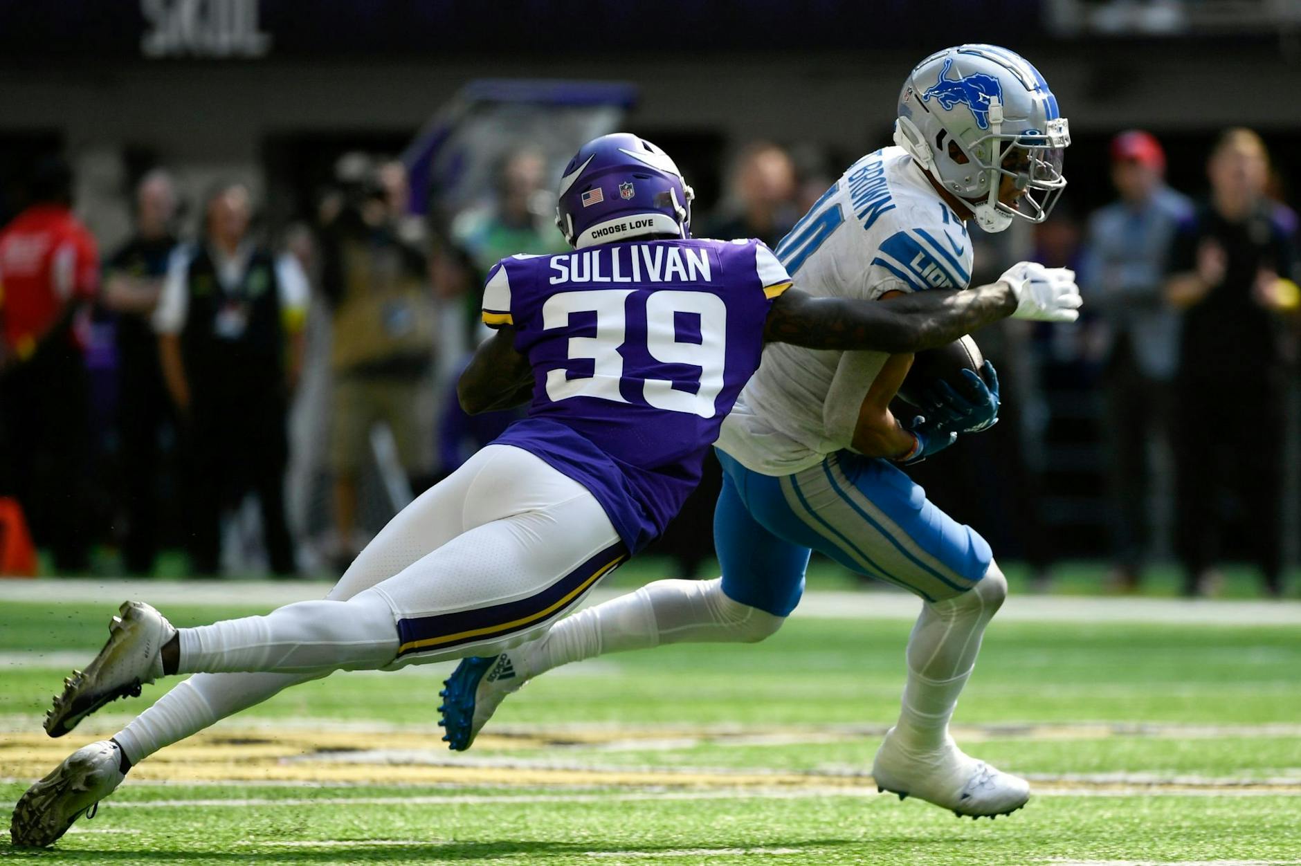 Vollen Körpereinsatz zeigen die NFL Profis im Spiel der Minnesota Vikings gegen die Detroit Lions. Detroits Wide Receiver Amon-Ra St. Brown (r) versucht, vor Vikings-Cornerback Chandon Sullivan davonzulaufen.