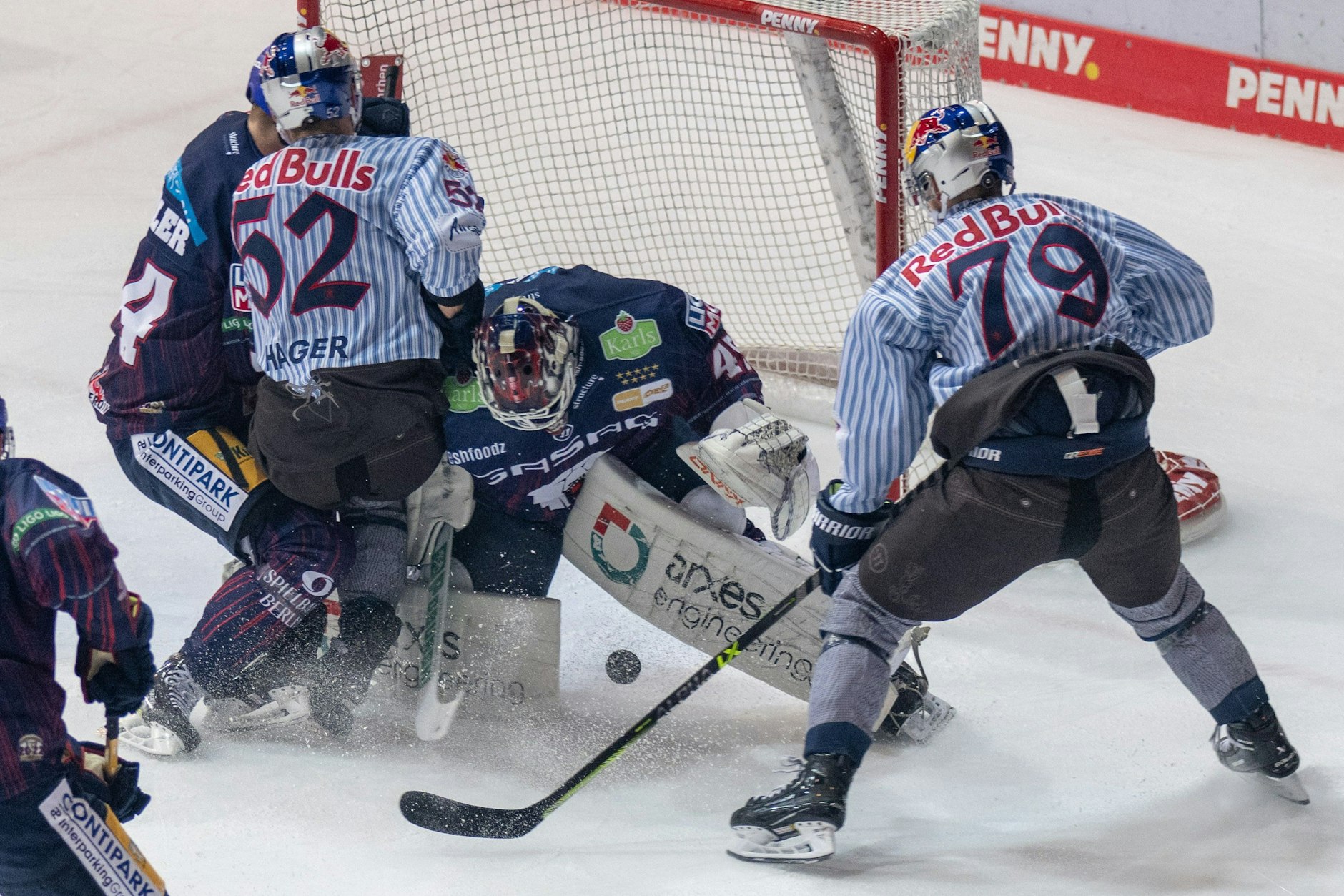Berlins Torwart Tobias Ancicka (M) in Aktoin gegen Münchens Patrick Hager (2.vl) und Philipp Krening.