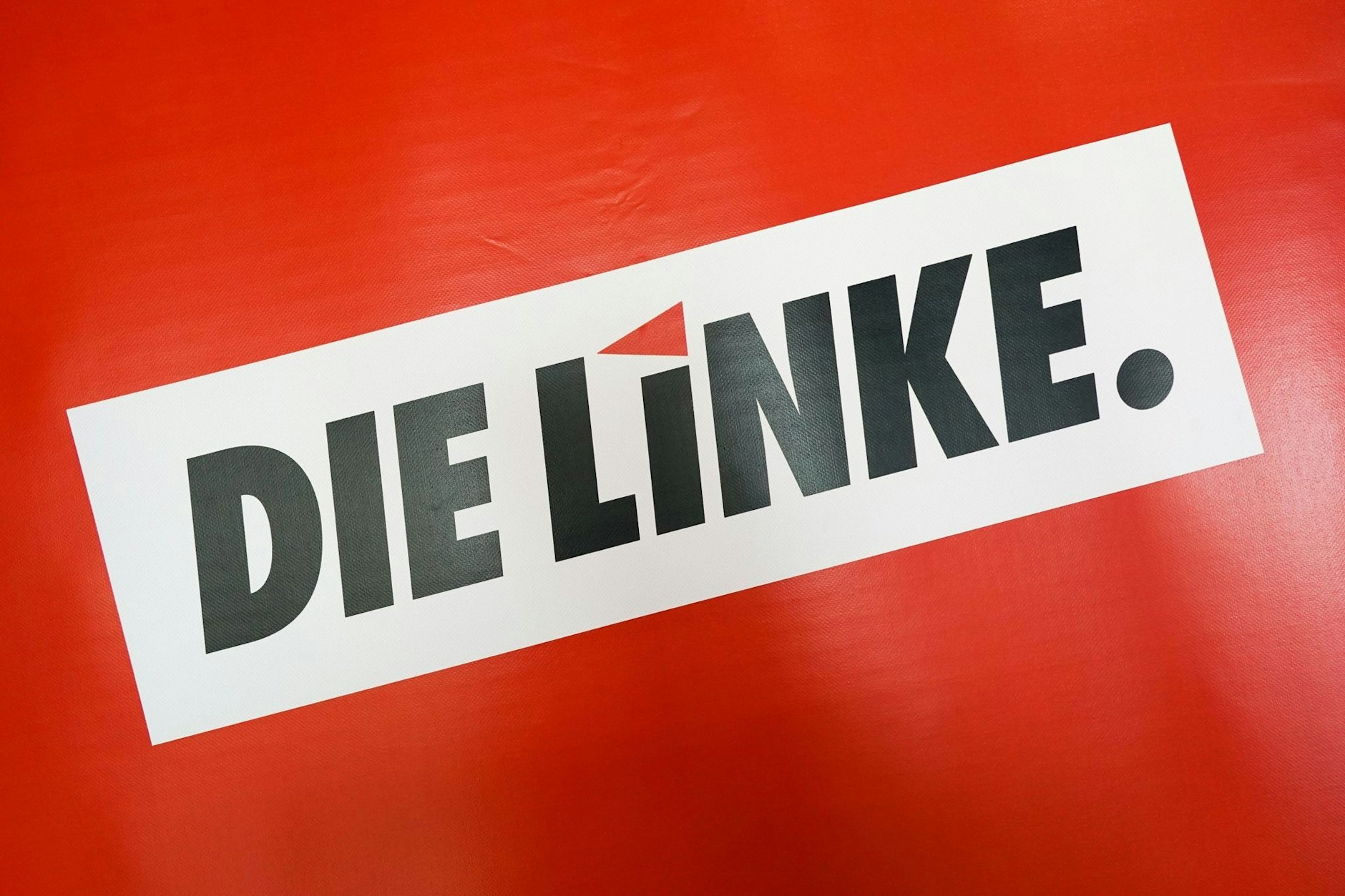 ARCHIV - Das Textlogo "Die Linke." steht auf rotem Grund während eines Landesparteitags. Am Samstag trifft sich Die Linke Hessen auf einem Landesparteitag in Dietzenbach.  