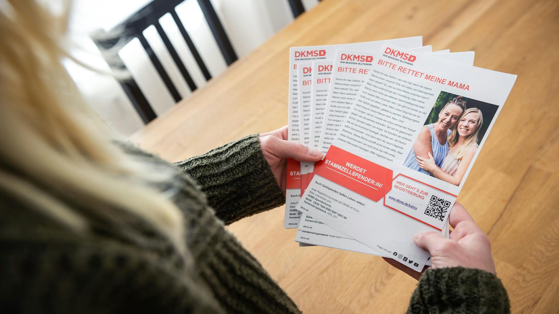 Gina hält einige der Flyer in den Händen, die sie in der Stadt verteilt. 