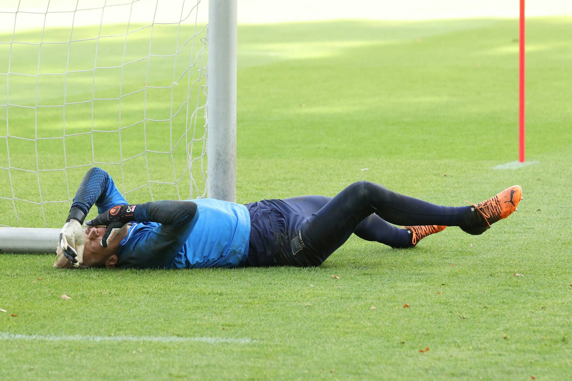 Herthas Torwart Oliver Christensen hält sich vor Schmerzen am Kopf. Der Keeper war im Training an den Pfosten gekracht.