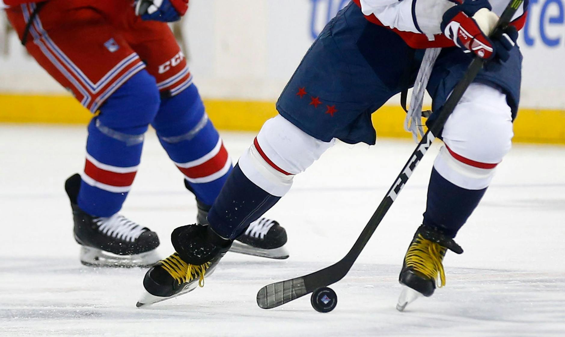 ARCHIV - Zwei Eishockeyspieler kämpfen um den Puck.