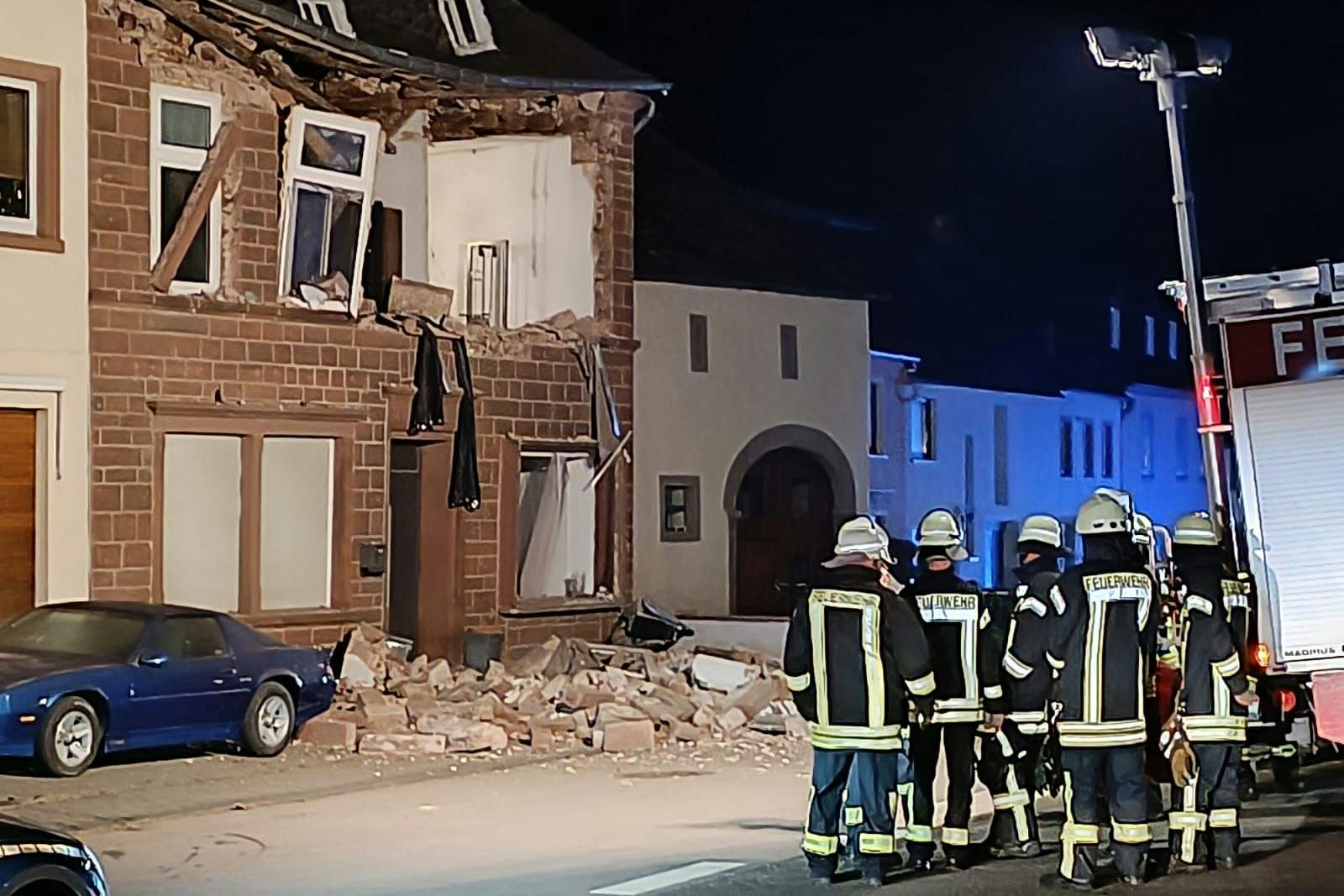 Feuerwehrleute stehen an der Einsatzstelle. In einem Einfamilienhaus in Spangdahlem im Eifelkreis Bitburg-Prüm hat es eine Explosion gegeben, bei der ein Bewohner verletzt worden ist.