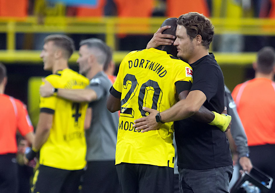 ARCHIV - Dortmunds Trainer Edin Terzic (r) umarmt Anthony Modeste. Hinten Marco Reus.   - Nutzung nur nach schriftlicher Vereinbarung mit der dpa