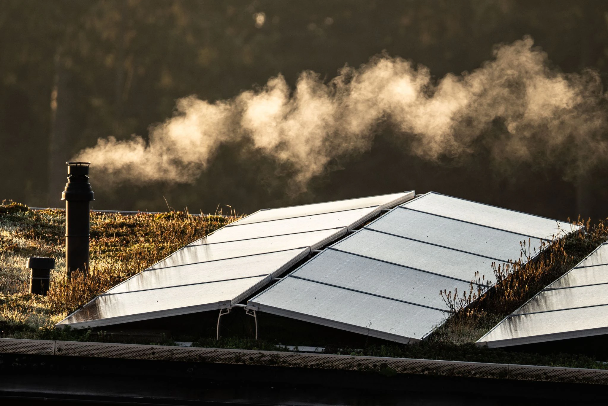 dpatopbilder - Der Schornstein einer Gastherme für die Heizung und die Warmwasserbereitung dampft am frühen Morgen auf dem Flachdach eines Frankfurter Reihenhauses, auf dem auch eine Solaranlage installiert ist.  