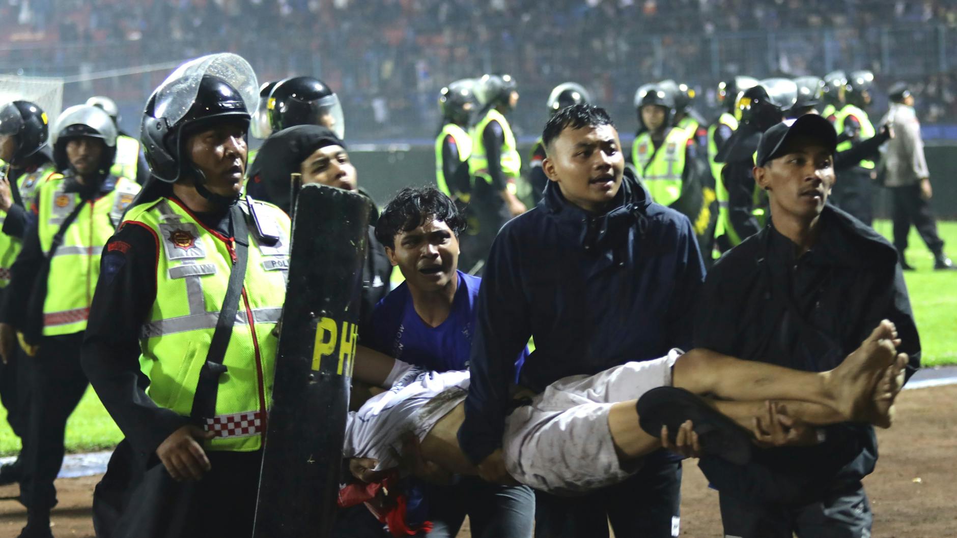 Fans tragen einen Mann aus dem Stadion in Malang.