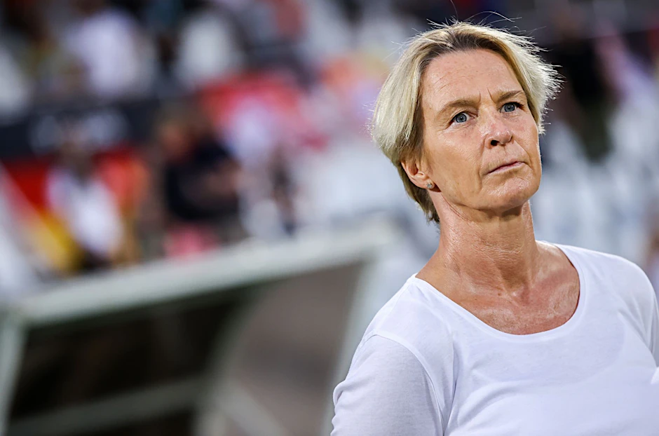 Bundestrainerin Martina Voss-Tecklenburg steht vor einem Spiel am Spielfeldrand.  