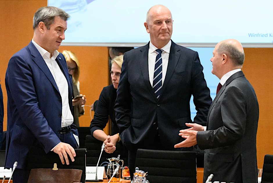 Markus Söder (l-r, CSU), Ministerpräsident von Bayern, Dietmar Woidke (SPD), Ministerpräsident von Brandenburg, und Bundeskanzler Olaf Scholz (SPD) unterhalten sich
            .  