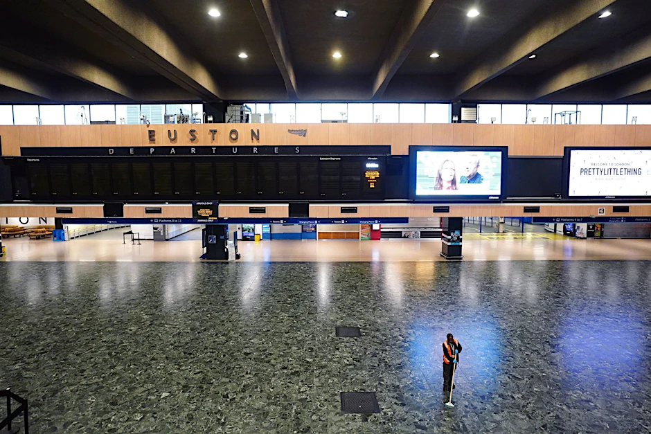 Eine Person wischt den Boden vor einer leeren Abfahrtstafel im Bahnhof Kings Cross, da die Mitglieder der Fahrergewerkschaft Aslef und der Transport Salaried Staffs Association (TSSA) streiken.  
