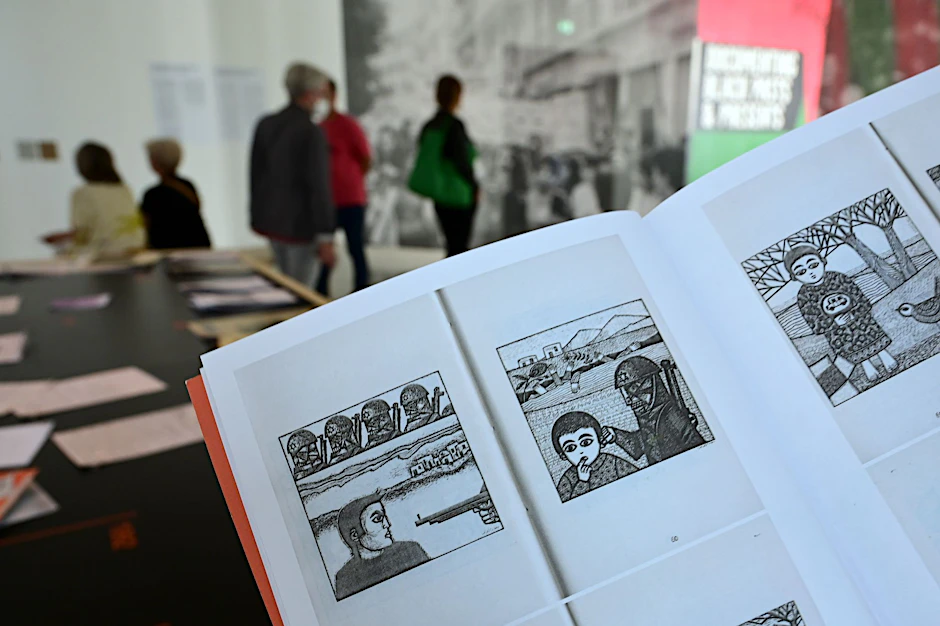 ARCHIV - Eine Frau hält auf der documenta fifteen im Fridericianum die Broschüre mit dem Titel «Presence des Femmes», die 1988 in Algier erschienen ist, in den Händen. Sie enthält weitere als antisemitisch kritisierte Motive.   - Nutzung nur nach schriftlicher Vereinbarung mit der dpa