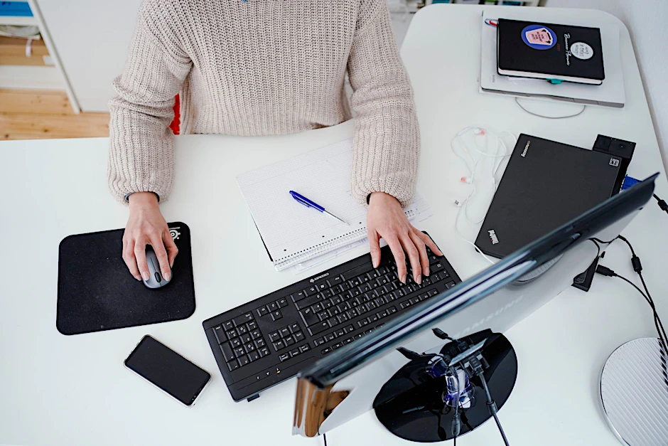 ARCHIV - Eine Frau arbeitet vor einem Computer an einem Stehtisch.  