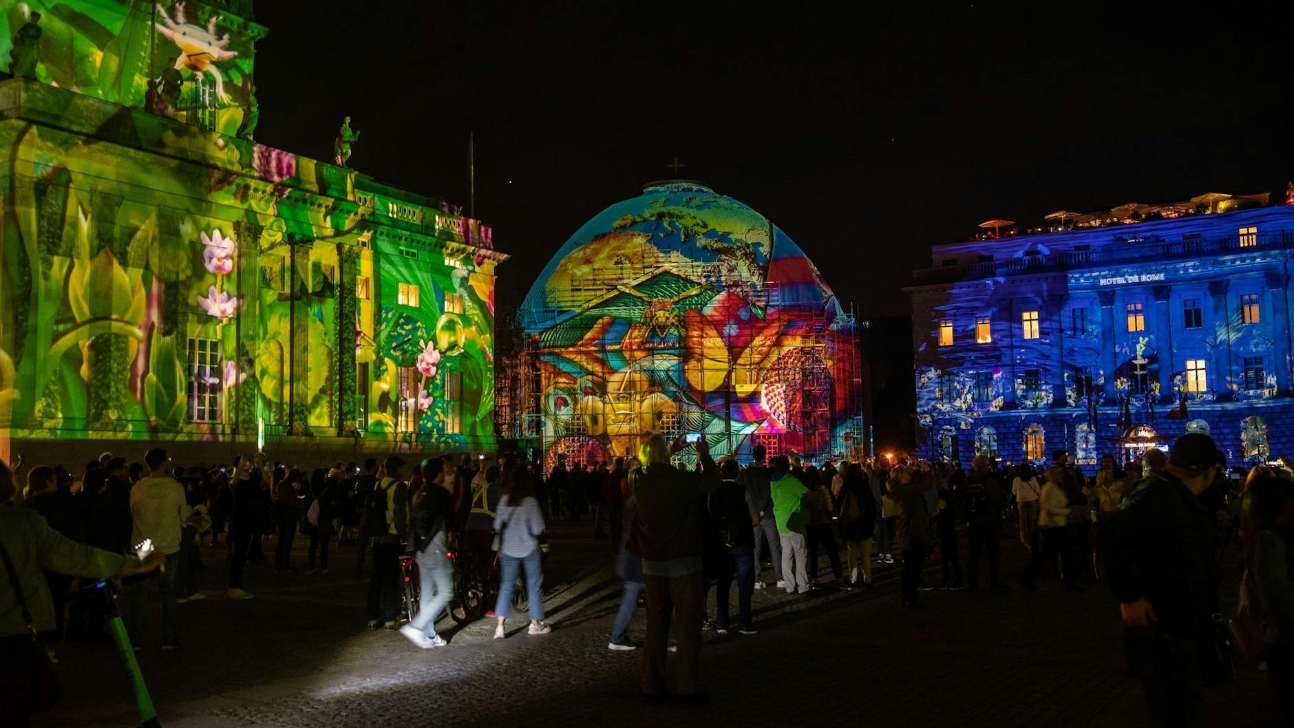 Zahlreiche Menschen stehen zum Auftakt des letzten Festival of Lights auf dem Bebelplatz. 
