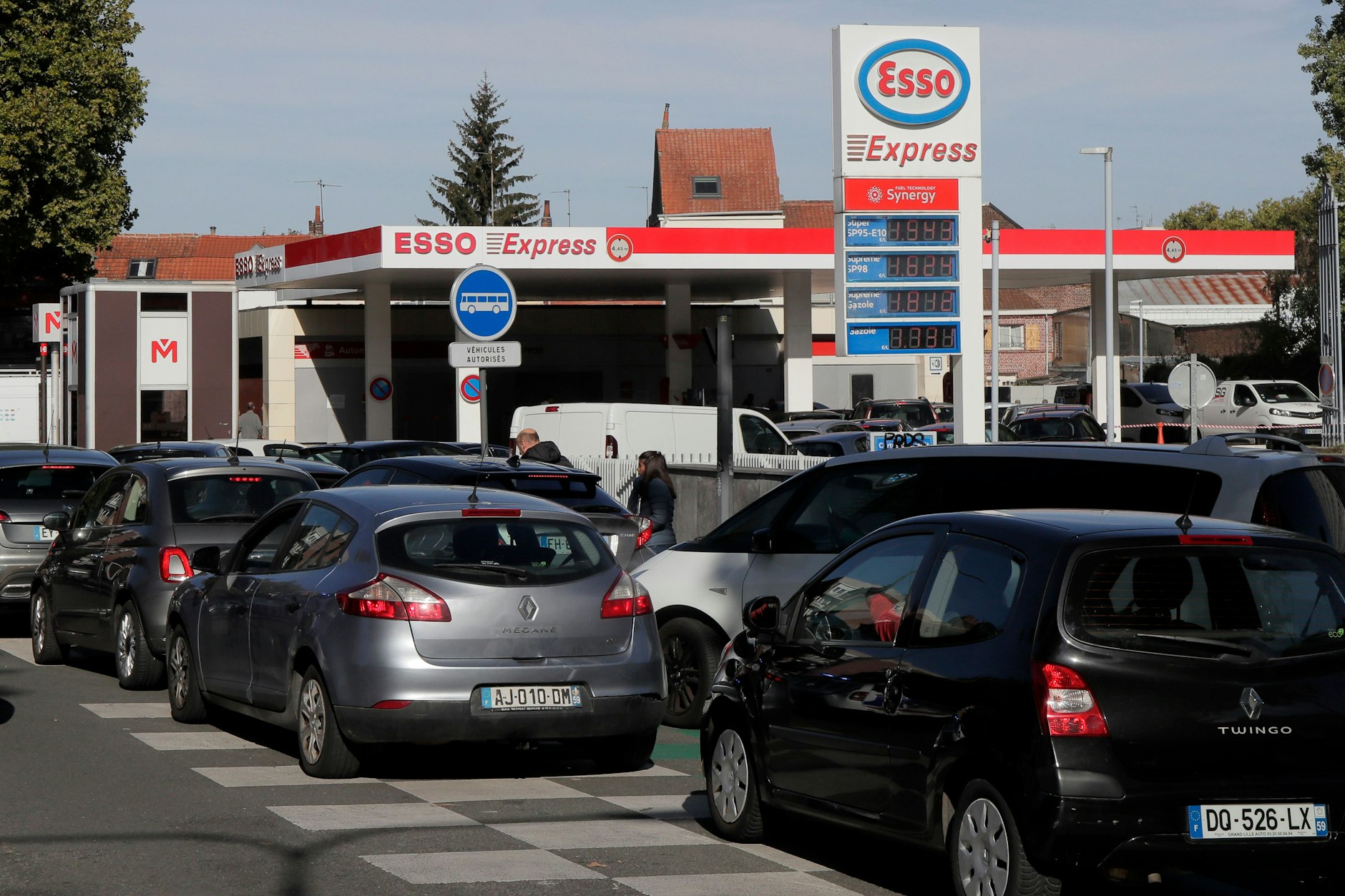Autofahrer stehen in Scharen an einer Tankstelle Schlange, um Benzin zu kaufen.