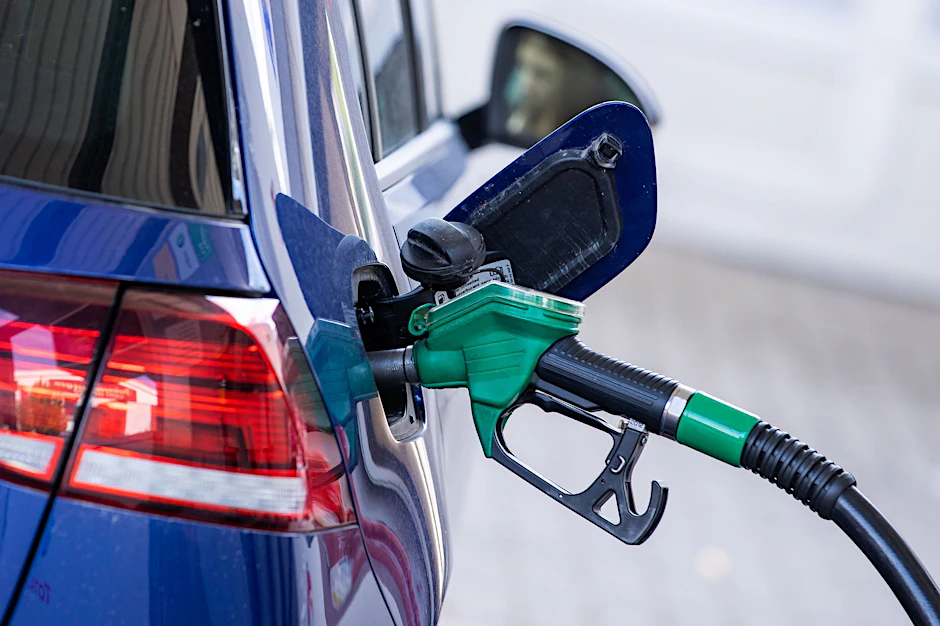 Eine Zapfpistole steckt an einer Tankstelle in einem Wagen.&nbsp;
