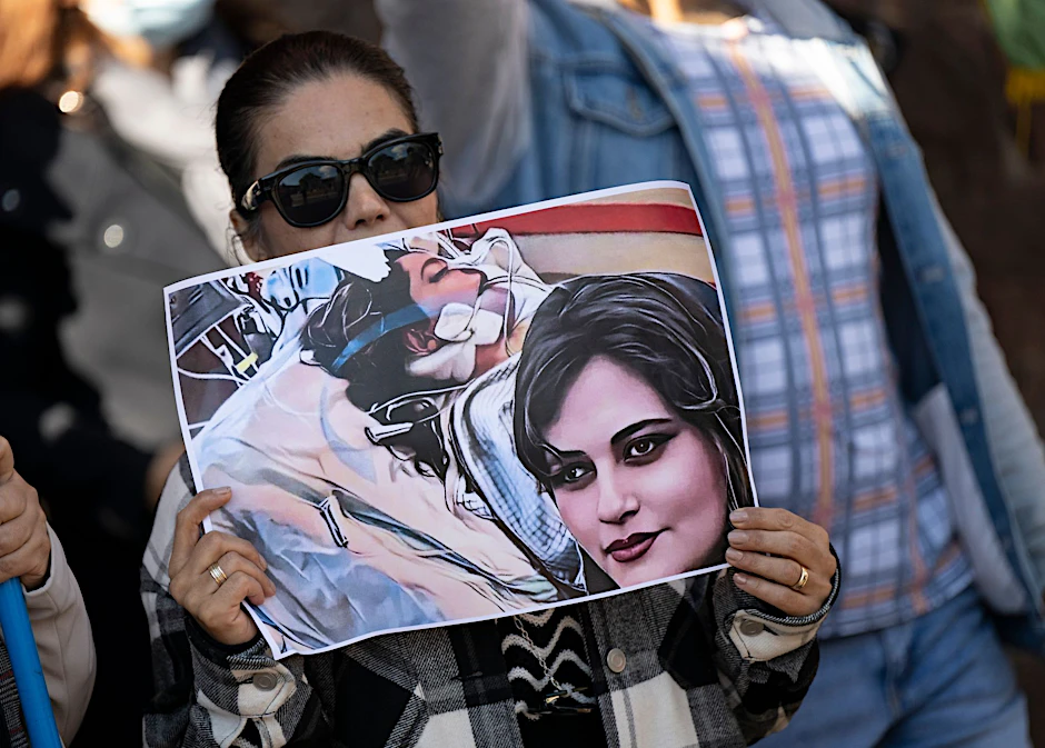 Eine Iranerin beteiligt sich in Frankfurt an einer Demonstration gegen das politische Regime im Iran. Dabei hält sie ein Plakat mit dem Bild der 22-jährigen  Mahsa Amini in den Händen.  