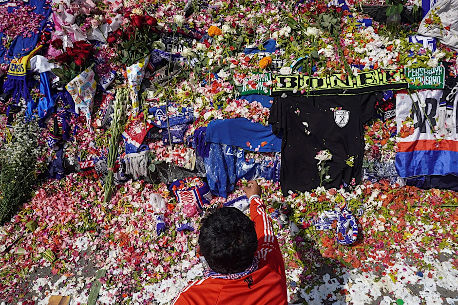 Ein Mann legt Blumen vor dem Kanjuruhan-Stadion nieder, wo mehr als 120 Menschen bei einer Massenpanik gestorben sind.  