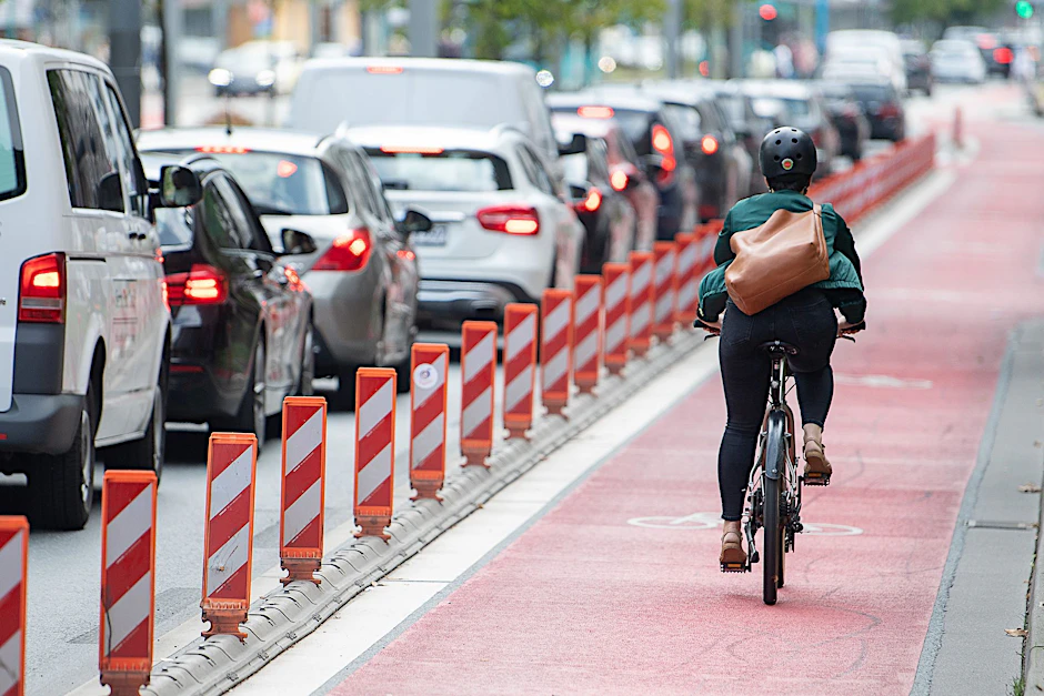 ARCHIV - Eine Fahrradfahrerin fährt auf einer Fahrradspur an einer Straße. Die Sorge vor den Folgen der Klimakrise ist für die Menschen in Deutschland die stärkste Motivation, ihr eigenes Mobilitätsverhalten zu ändern.  