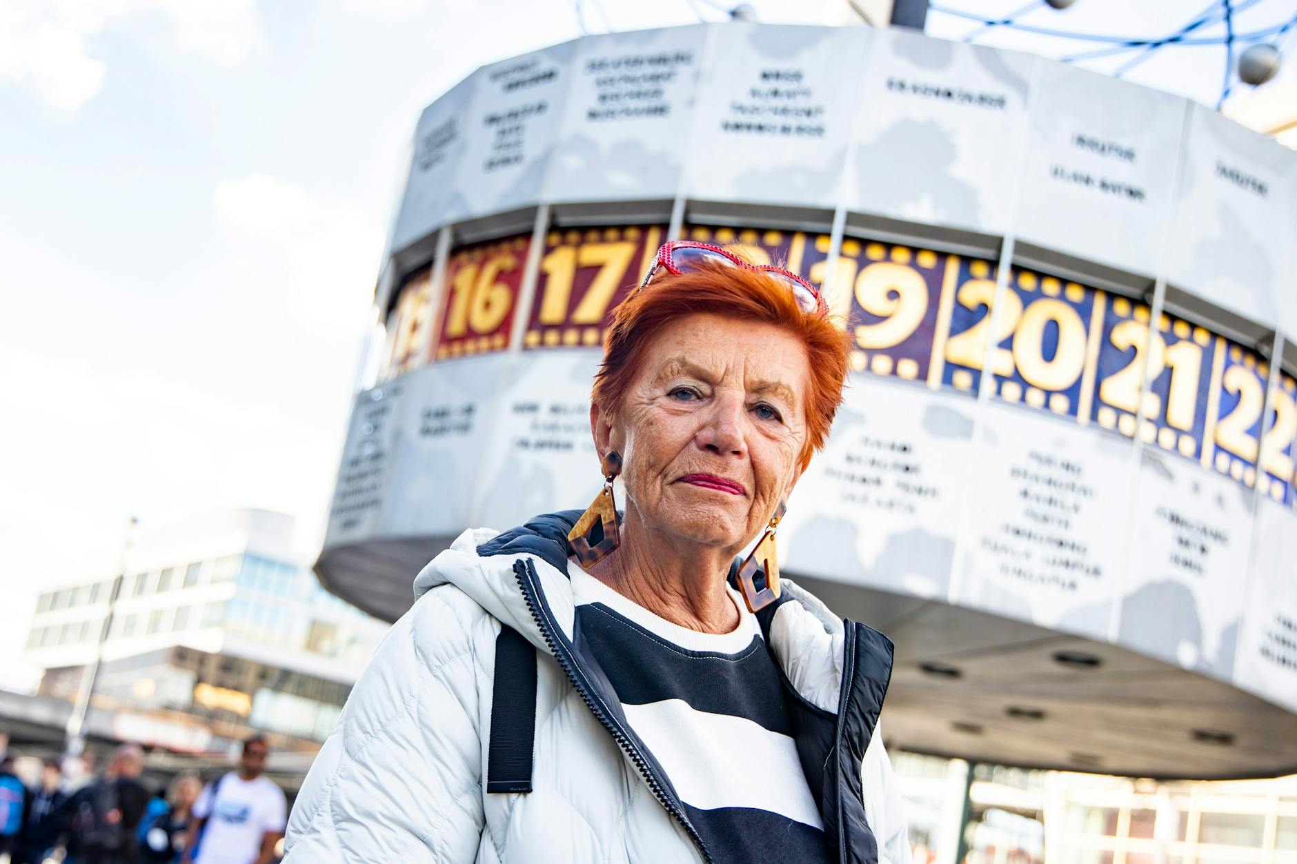 Hannelore Helm steht vor der Weltzeituhr am Alexanderplatz.