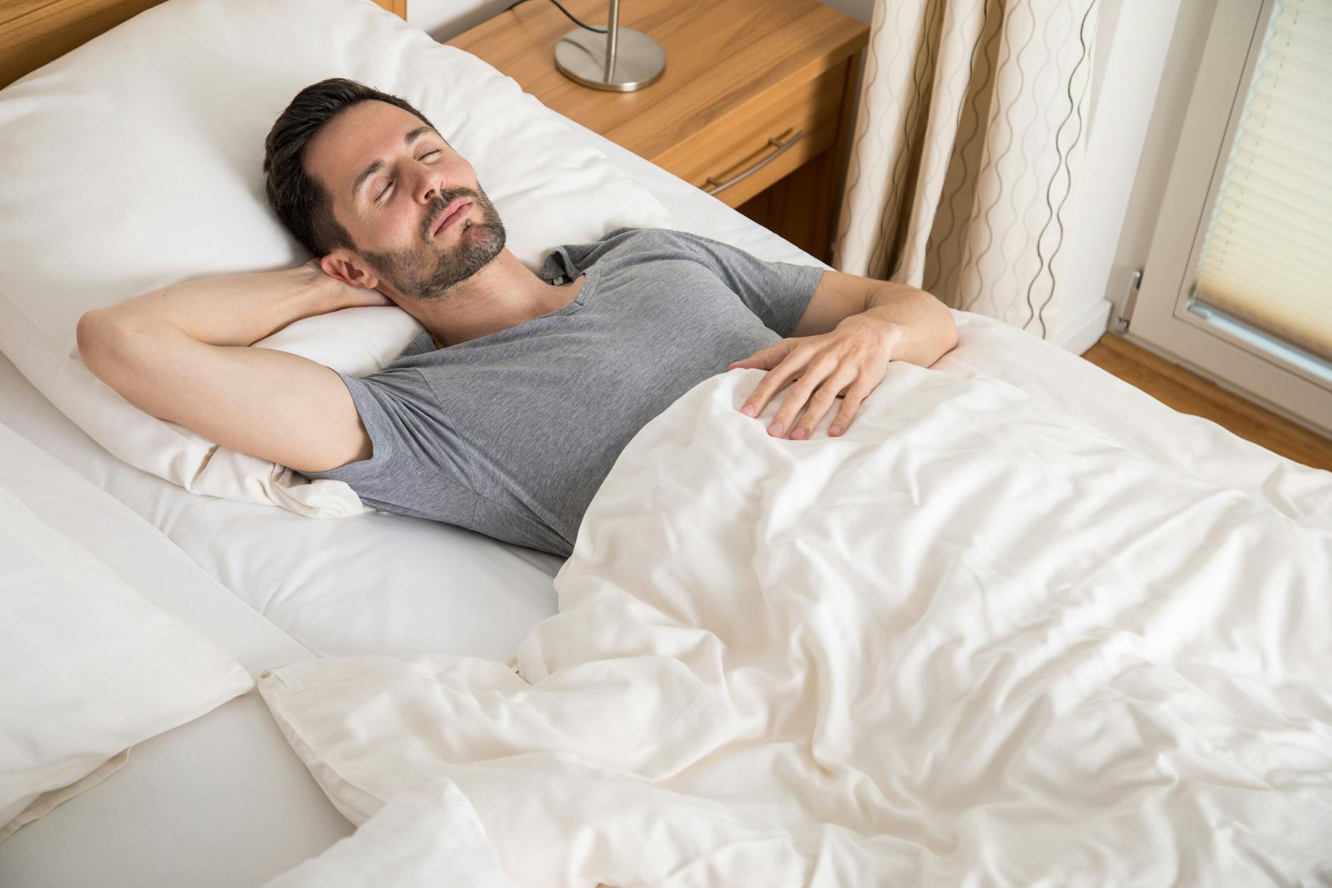 Ein junger Mann liegt in einem Bett.