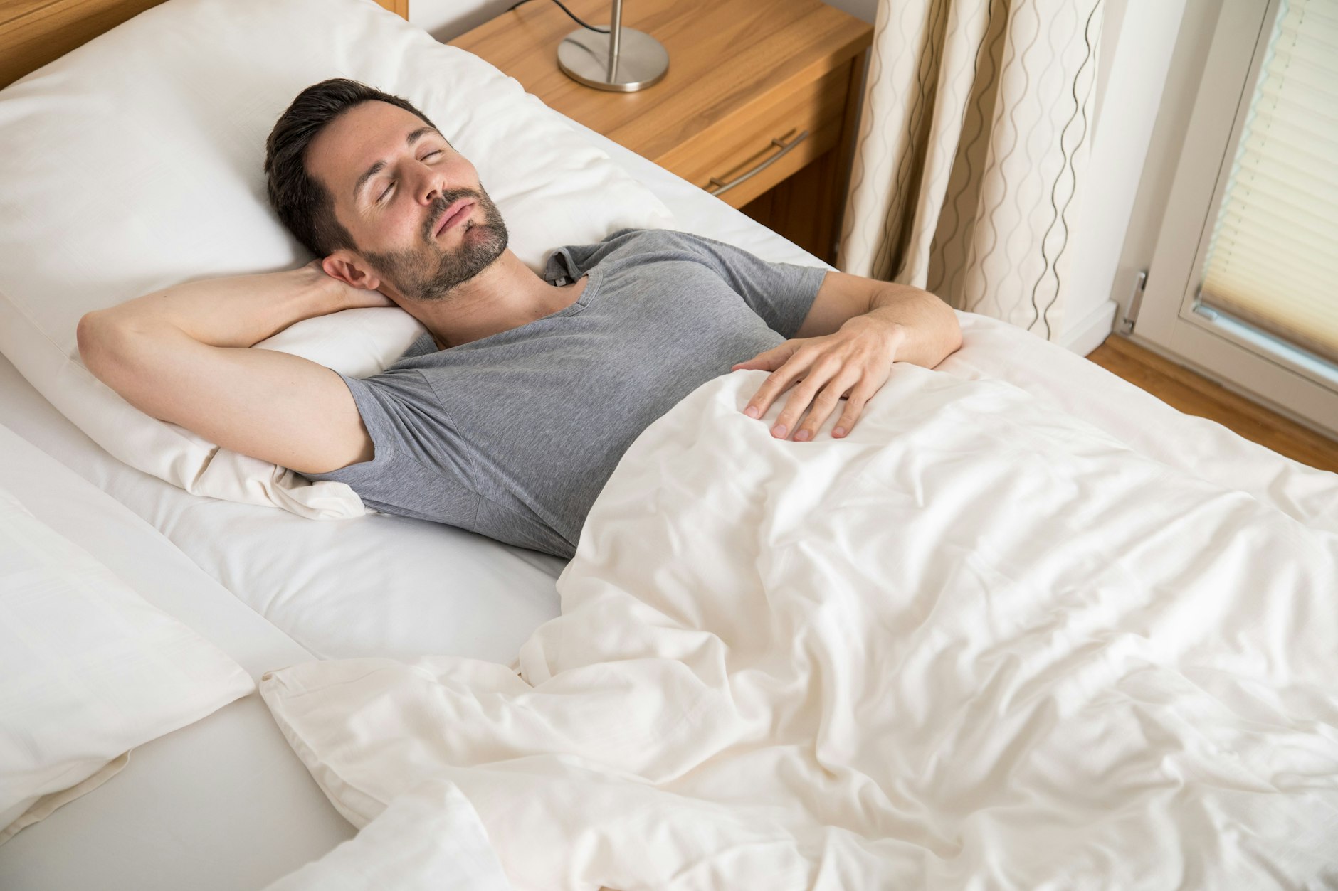 Ein junger Mann liegt in einem Bett.