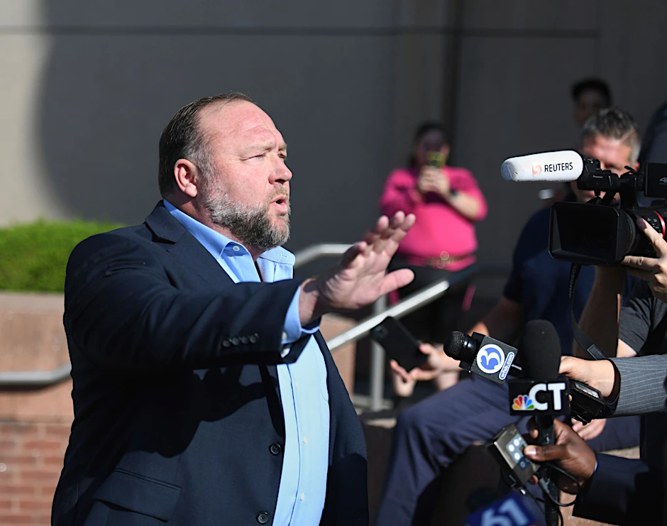 Alex Jones spricht zu Journalisten, bevor er das Gericht in Waterbury betritt.