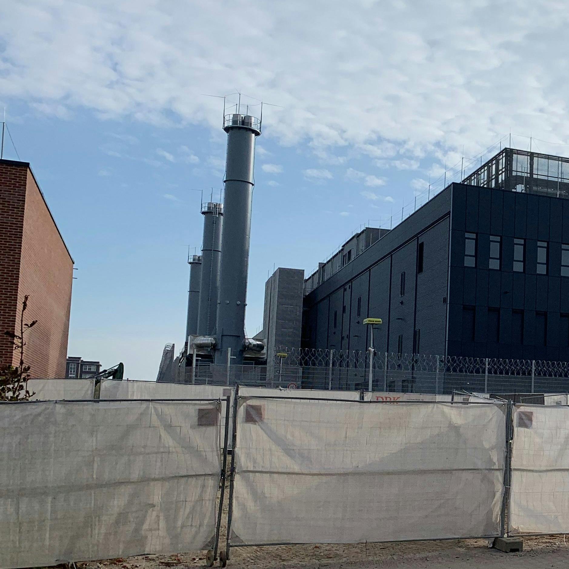Neben dem Rechenzentrum ragen die drei Schlote der Notstromaggregate auf.
