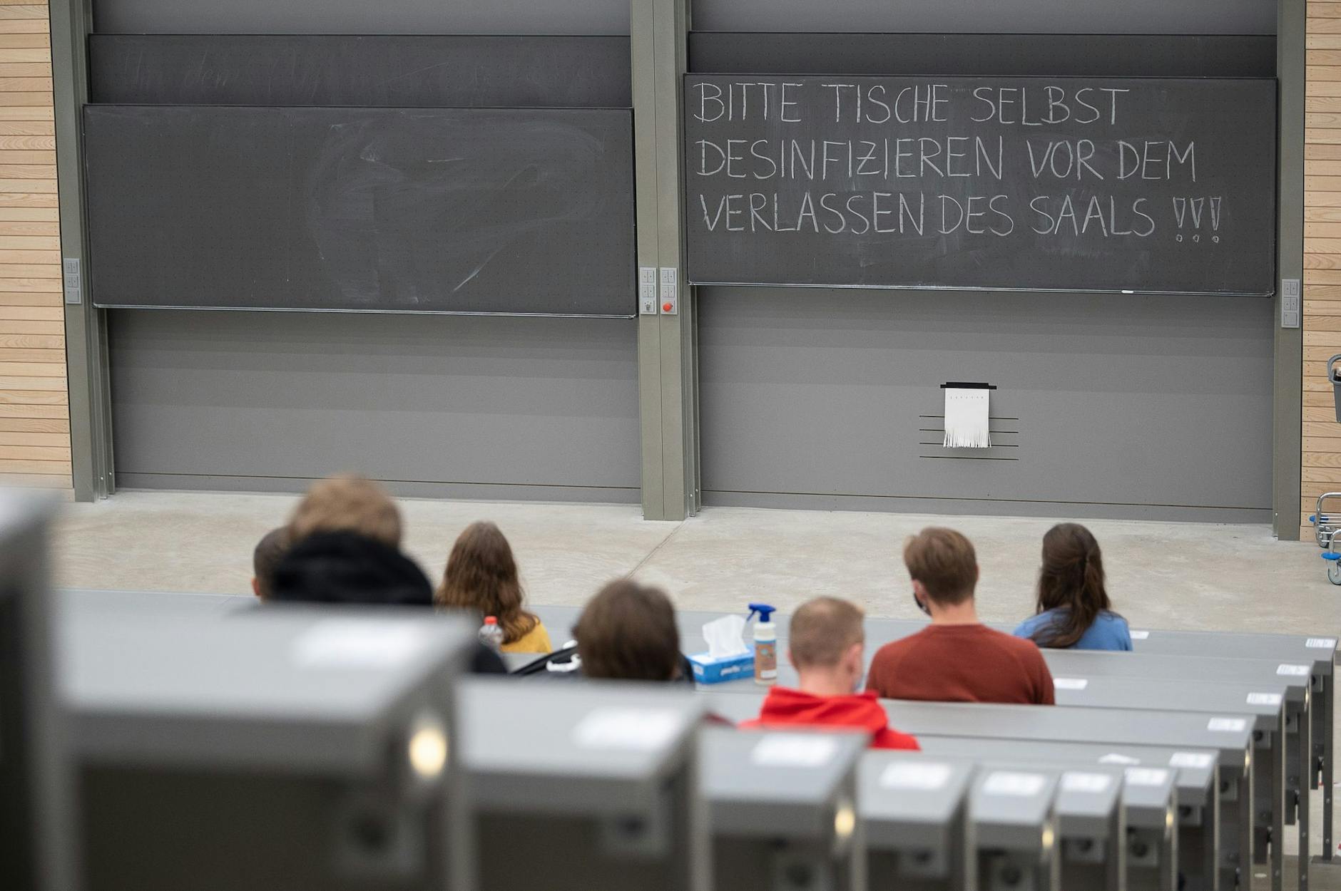 ARCHIV - Studierende mit Mund- und Nasenmaske sitzen in einem Hörsaal.