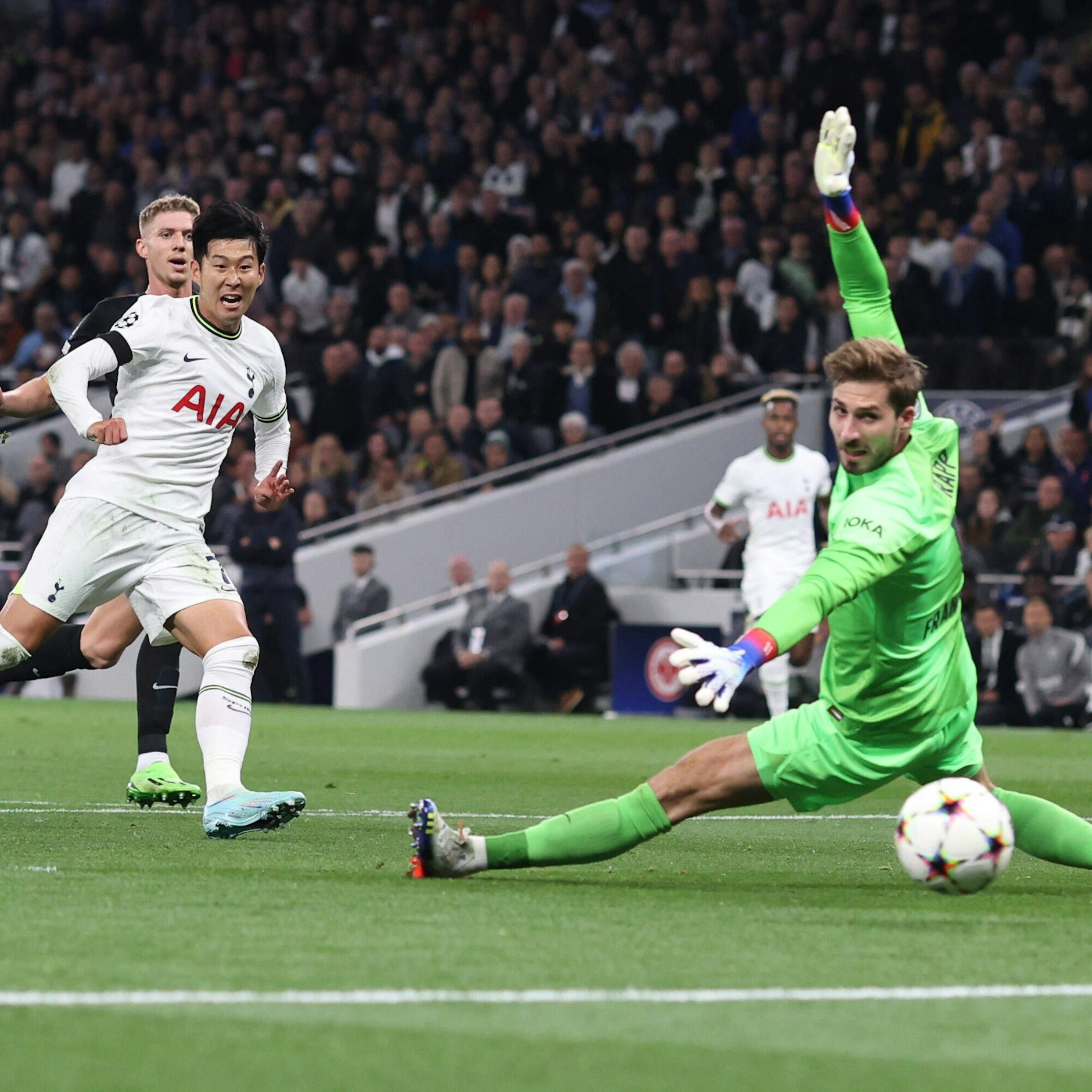 Tottenhams Son Heung-Min legt die Kugel vorbei an Frankfurts Keeper Kevin Trapp.