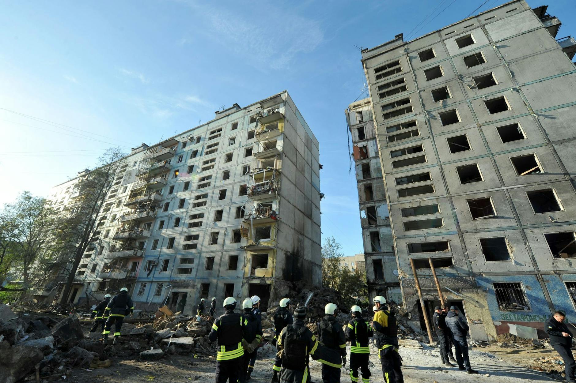 Rettungskräfte beseitigen in Saporischschja Trümmer nach Raketenangriffen.
